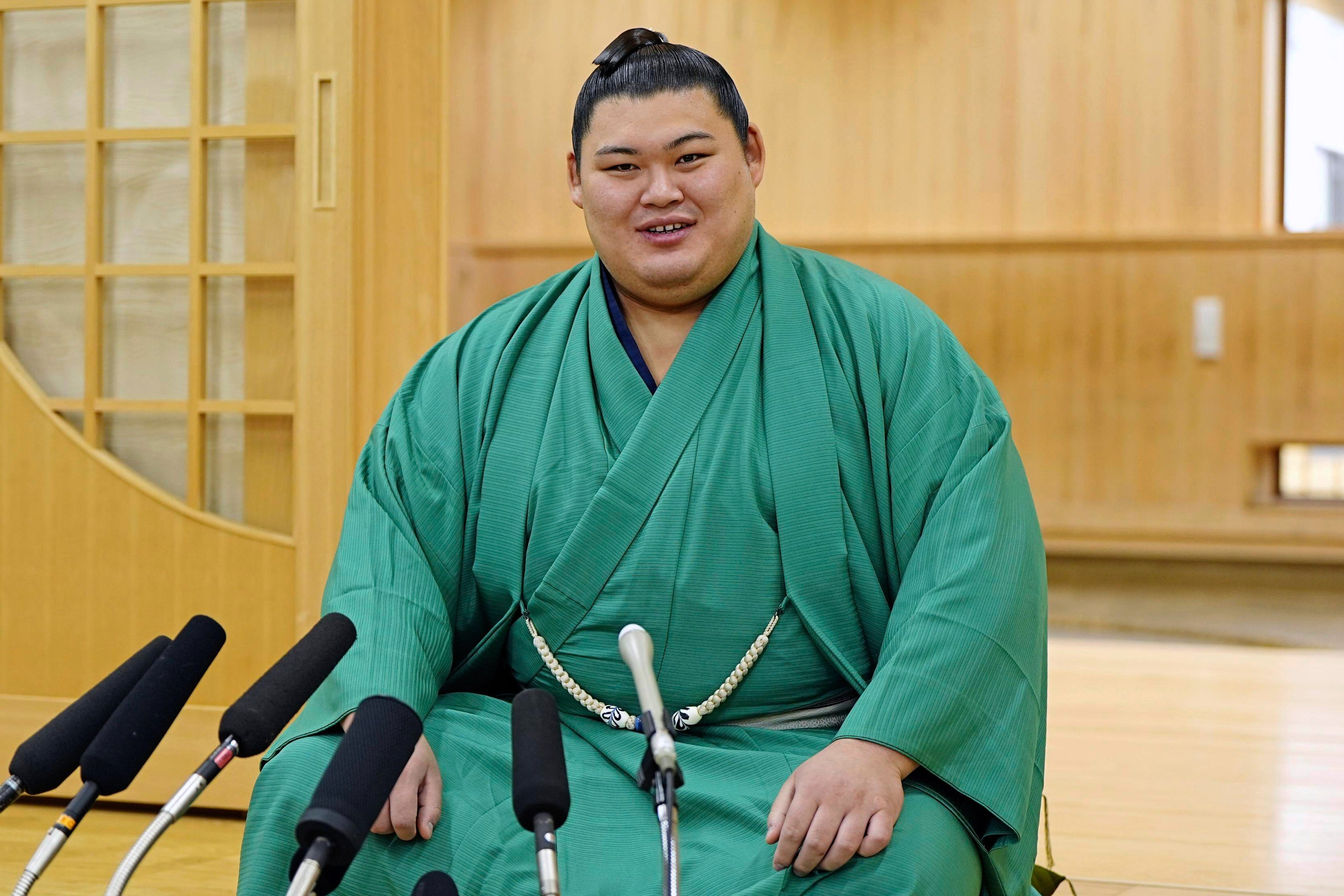 Onosato speaks during an interview with media members at his sumo training facility after winning a sumo wrestling tournament in Ami, northeast of Tokyo