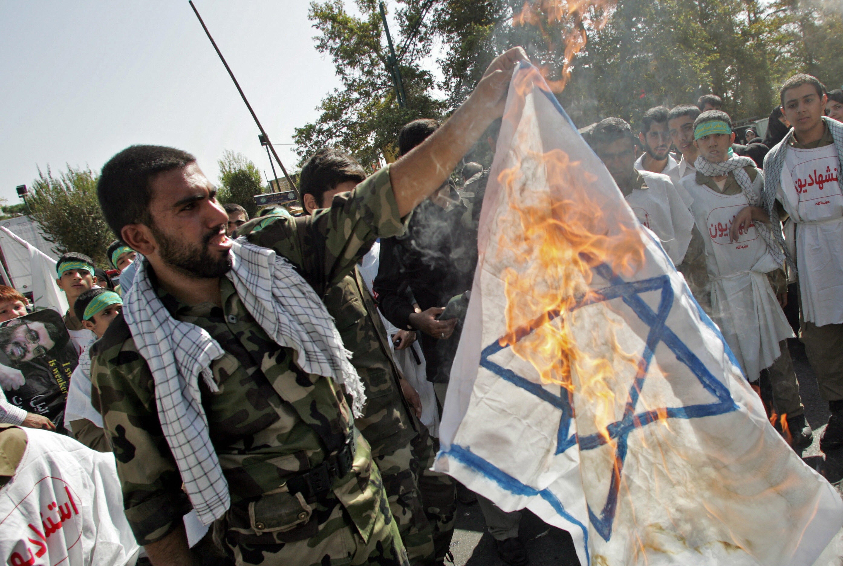 A member of Iran’s Revolutionary Guards burns an Israeli flag during a demonstration held in Tehran to mark Jerusalem (Al-Quds) Day in October 2006.