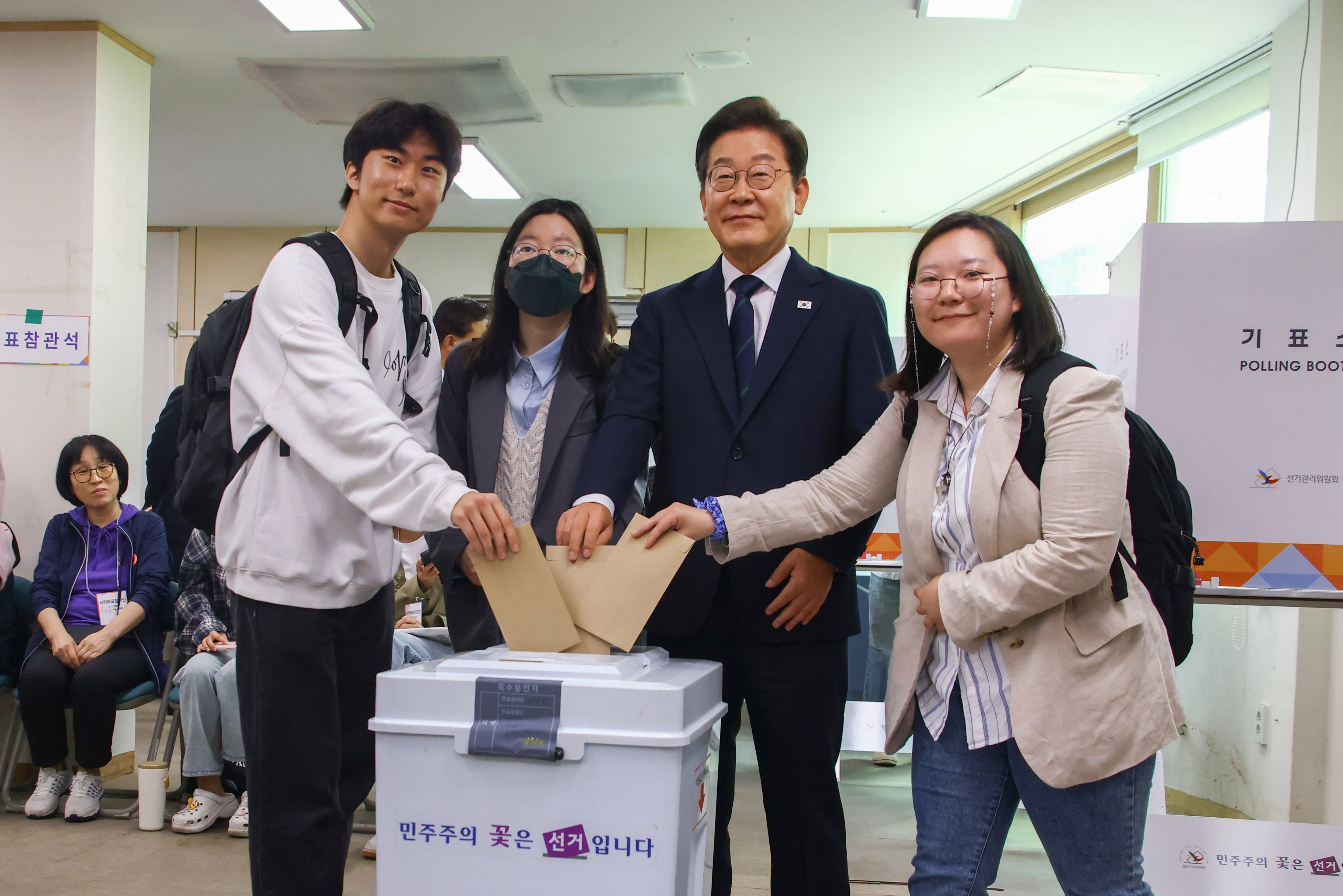 <p>Democratic Party's presidential candidate Lee Jae Myung, second from right, casts his early vote at a polling station in Seoul, South Korea, on 29 May 2025</p>
