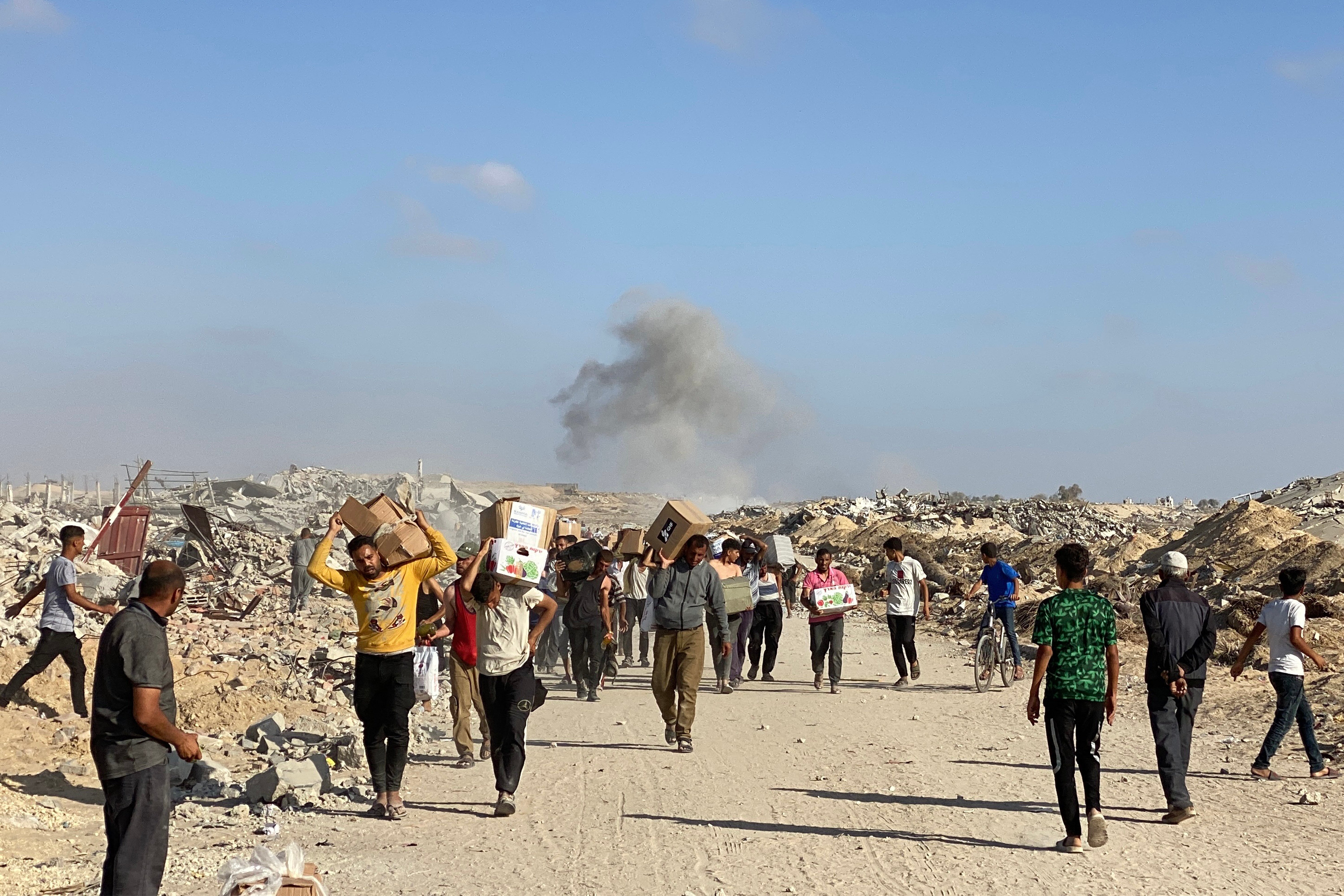 Displaced Palestinians receive food packages from a US-backed foundation pledging to distribute humanitarian aid in western Rafah in the southern Gaza Strip on 27 May 2025