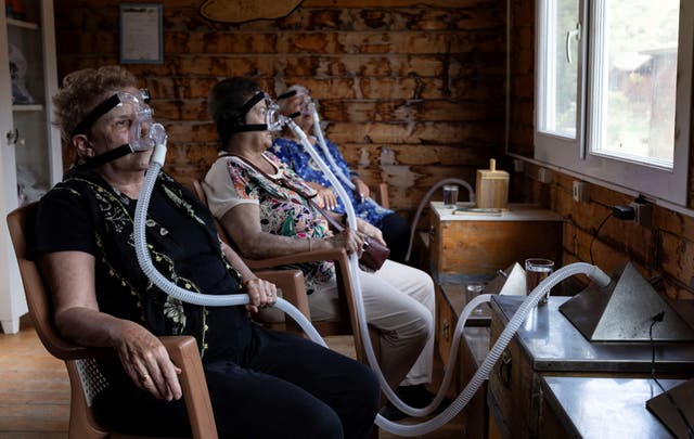 <p>Senay Ilhan and Ulku Ozman breathe in air from beehives through ventilators</p>