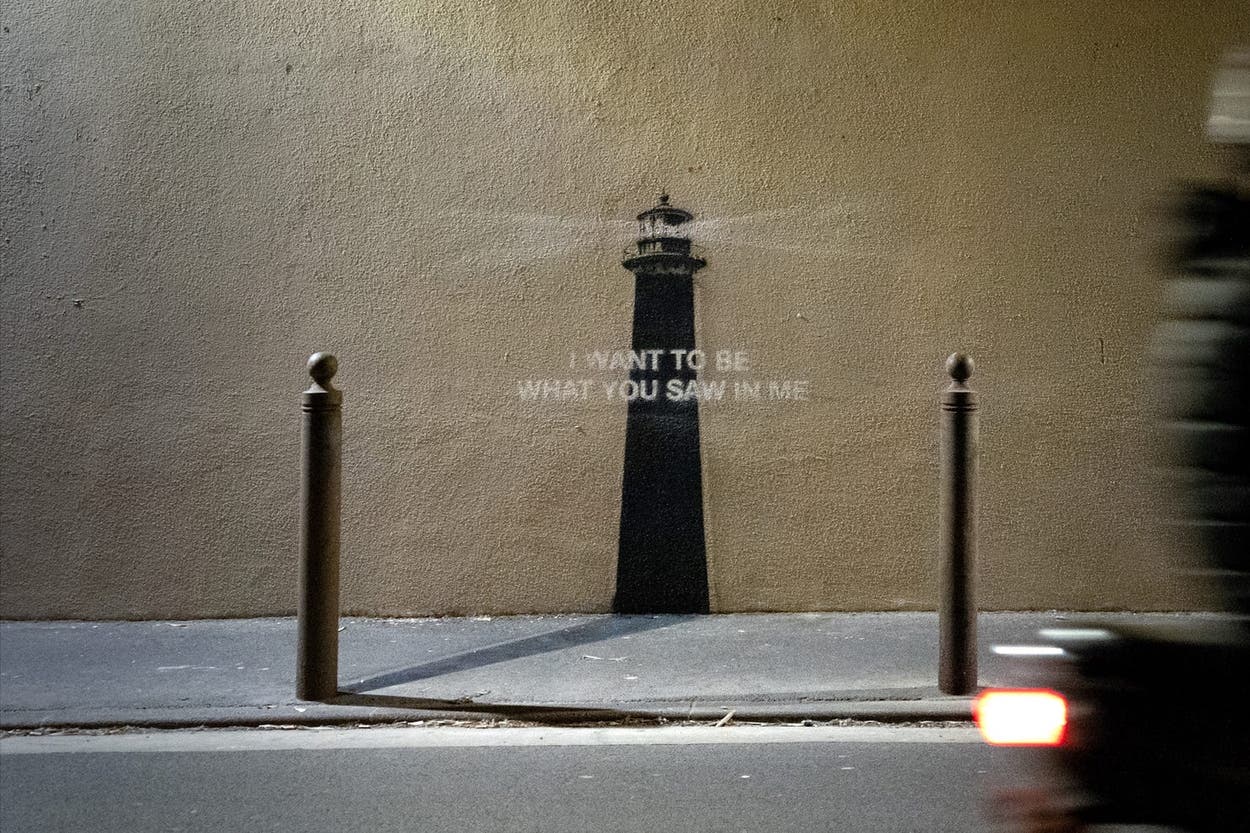 A lighthouse mural with text reading 'I WANT TO BE WHAT YOU SAW IN ME'
