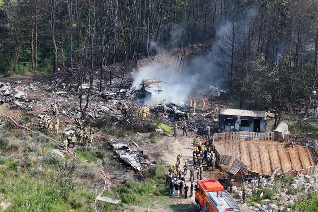 <p>Firefighters work at the site where a South Korean navy maritime patrol aircraft crashed on a mountain in Pohang on </p>