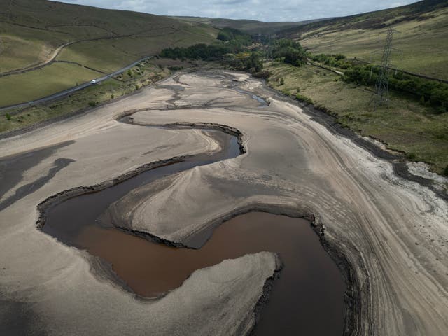 <p>An aerial photo from 22 May shows the bed of Woodhead Reservoir is partially revealed by a falling water level, near Glossop</p>