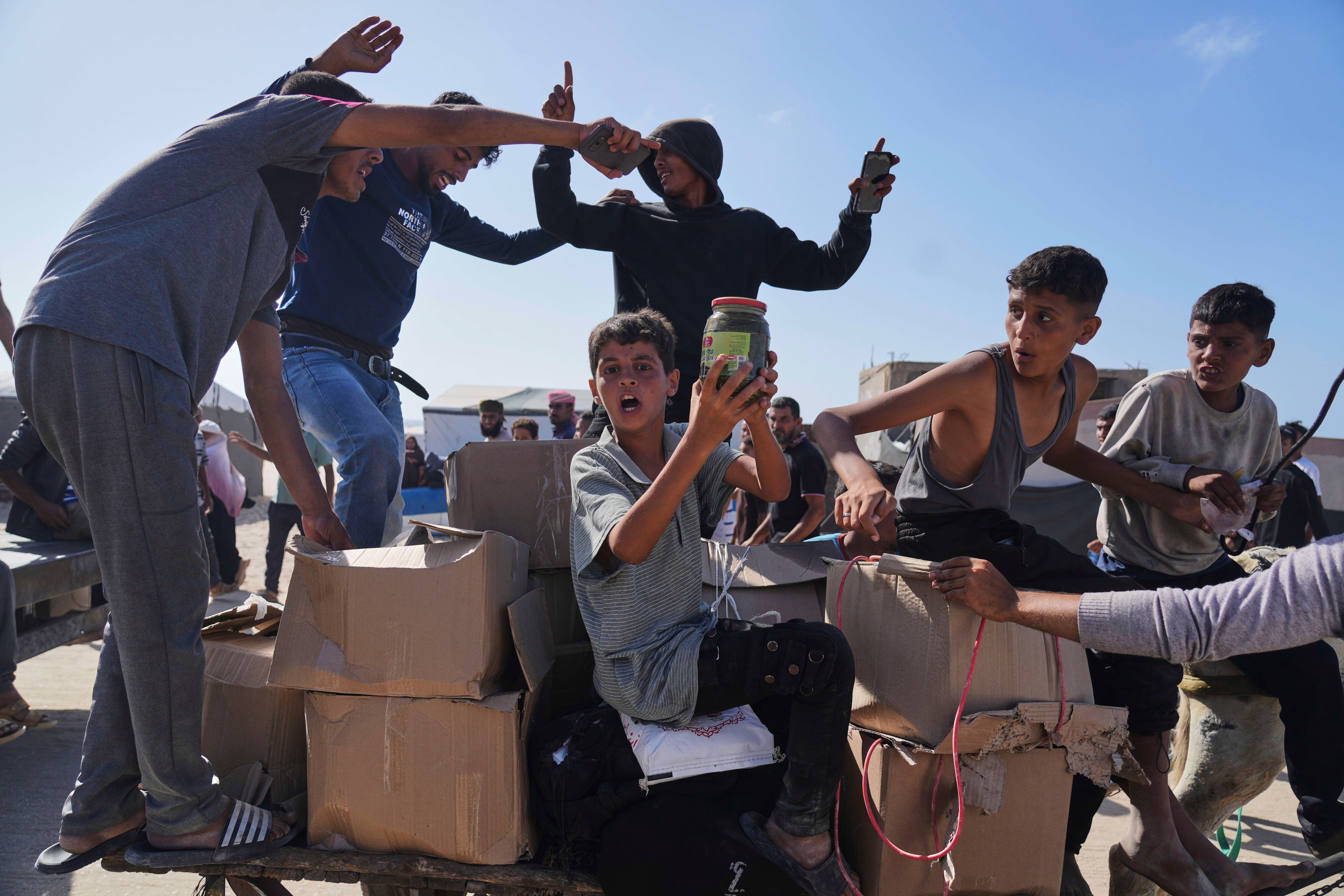 Palestinians carry boxes containing food and humanitarian aid packages delivered by Gaza Humanitarian Foundation, a controversial group backed by the US and Israel, in Rafah on 27 May 2025
