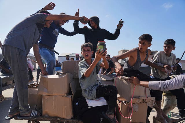 <p>Palestinians carry boxes containing food and humanitarian aid packages delivered by Gaza Humanitarian Foundation, a controversial group backed by the US and Israel, in Rafah on 27 May 2025</p>