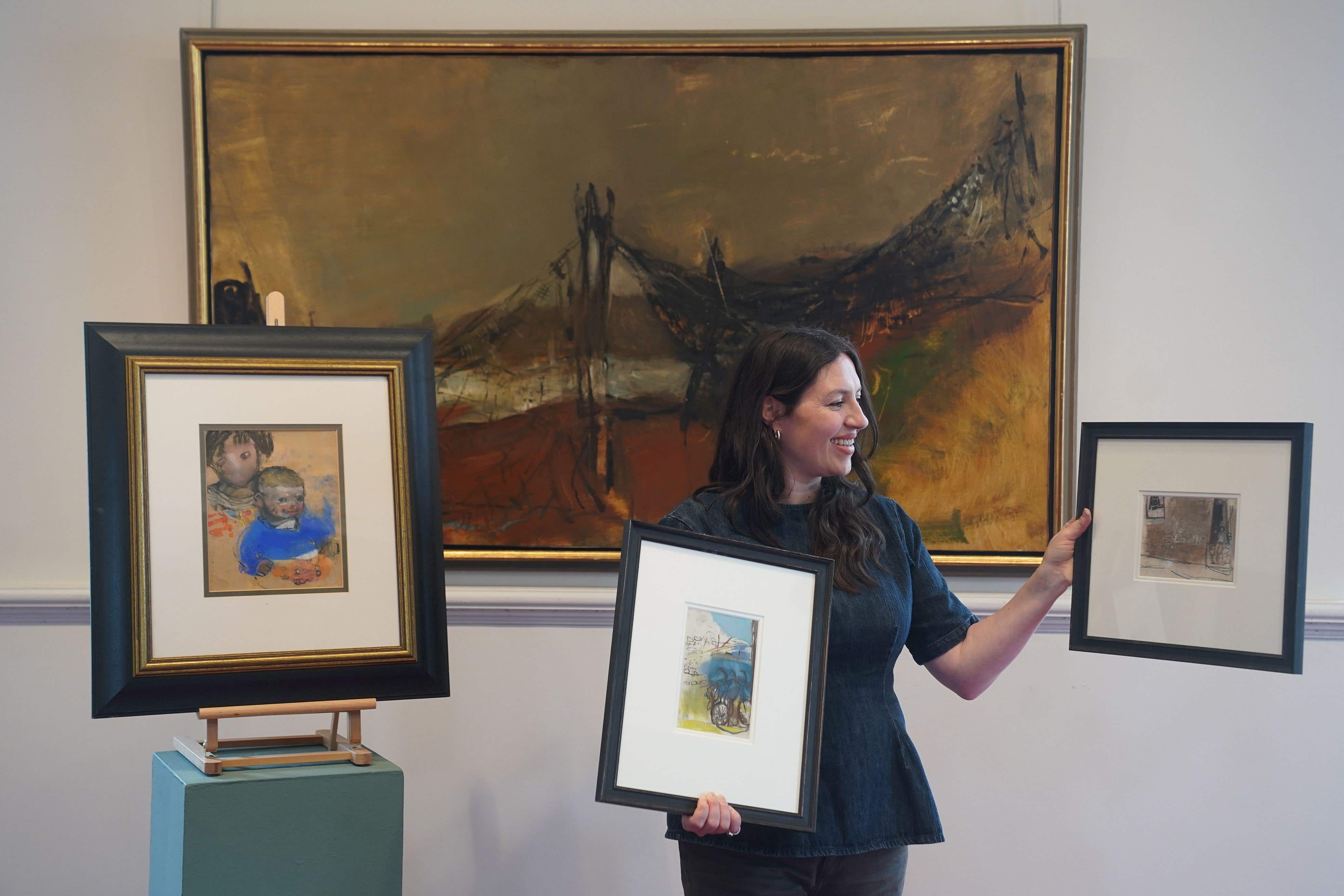 Senior specialist, Charlotte Riordan, with works by Joan Eardley (Stewart Attwood/PA Wire).