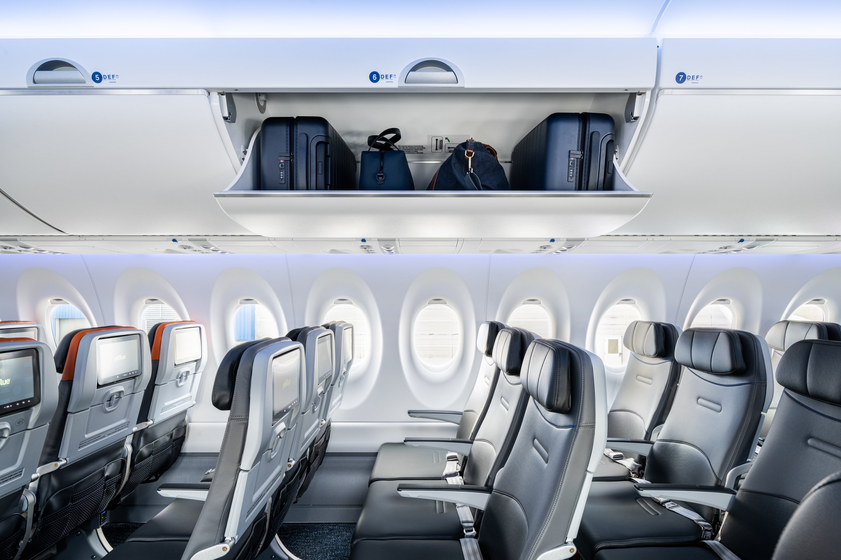 Above are the overhead bins in a JetBlue economy cabin. There is no weight limit for carry-on bags