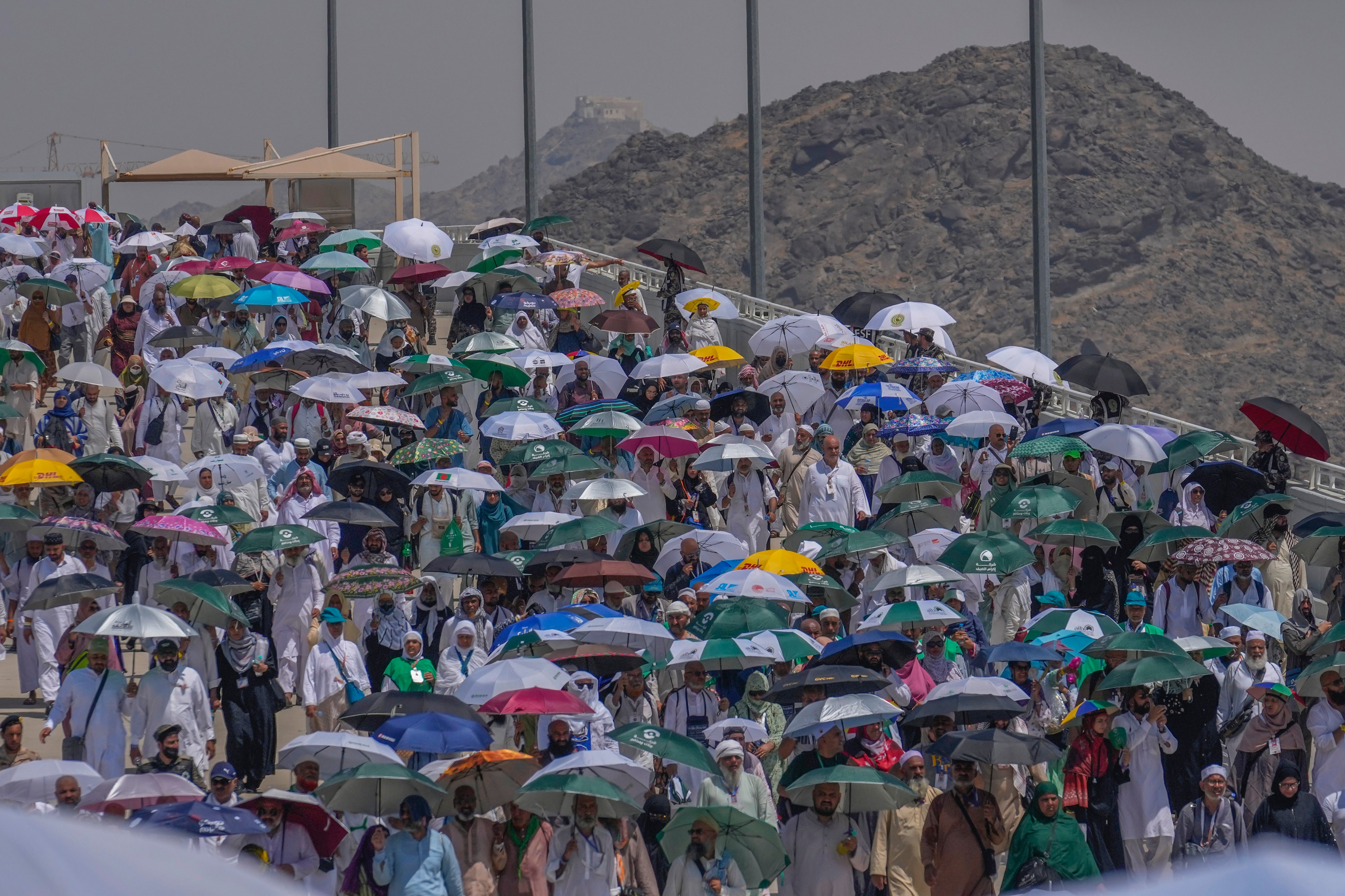 Muslim pilgrims use umbrellas to shield themselves from the sun as they arrive in Mina, near the holy city of Mecca