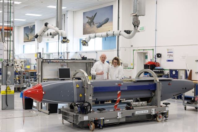 <p>Louise Holmes, MBDA UK Deputy Managing Director, shows Britain's Defence Secretary John Healey, left, a storm shadow missile on an assembly line at the MBDA Storm Shadow factory in Stevenage, England</p>