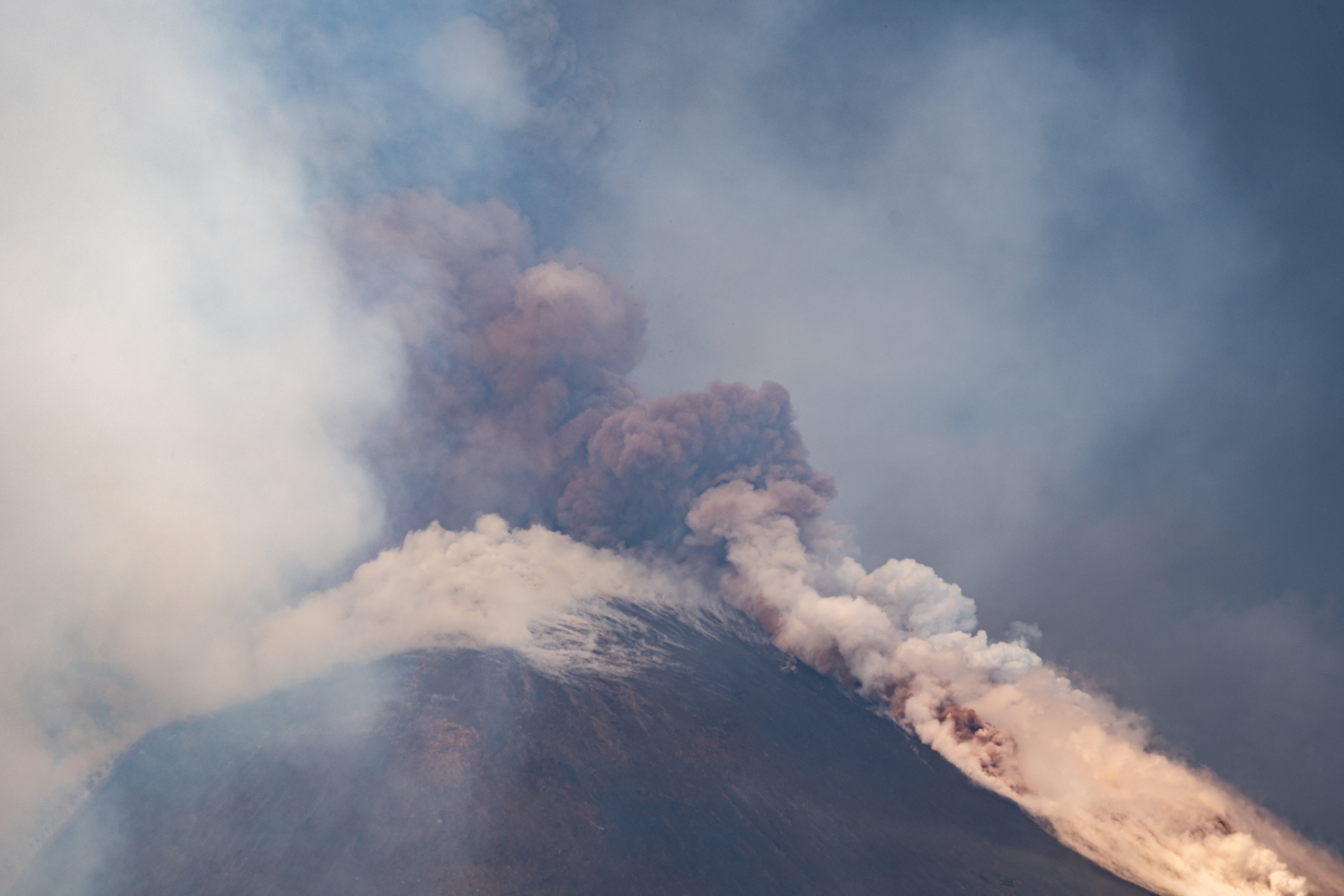 Volcanic steam rises from Mount Etna, as seen from Milo, Italy