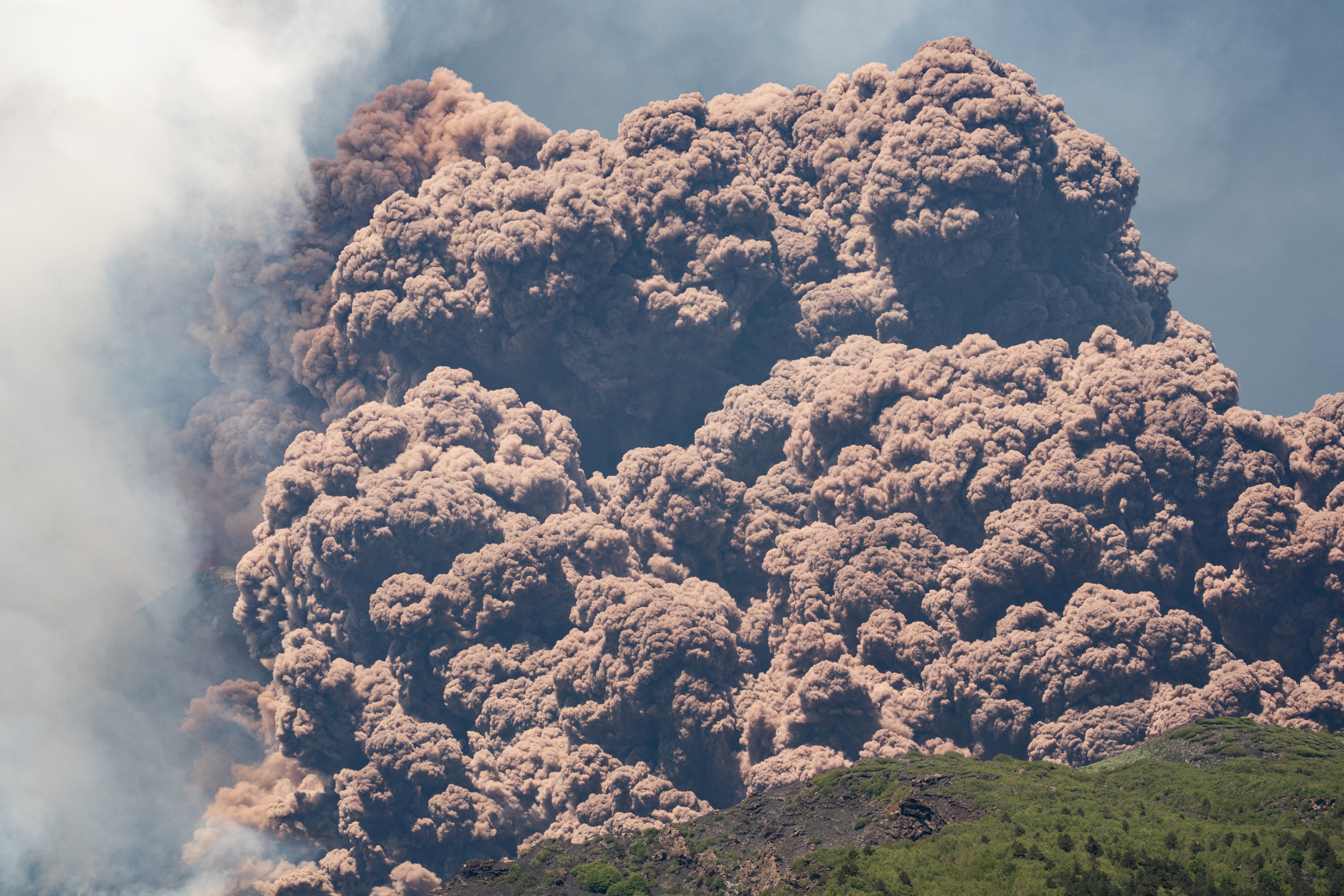 Plumes of ash and volcanic steam rise from Mount Etna, as seen from Milo, Italy