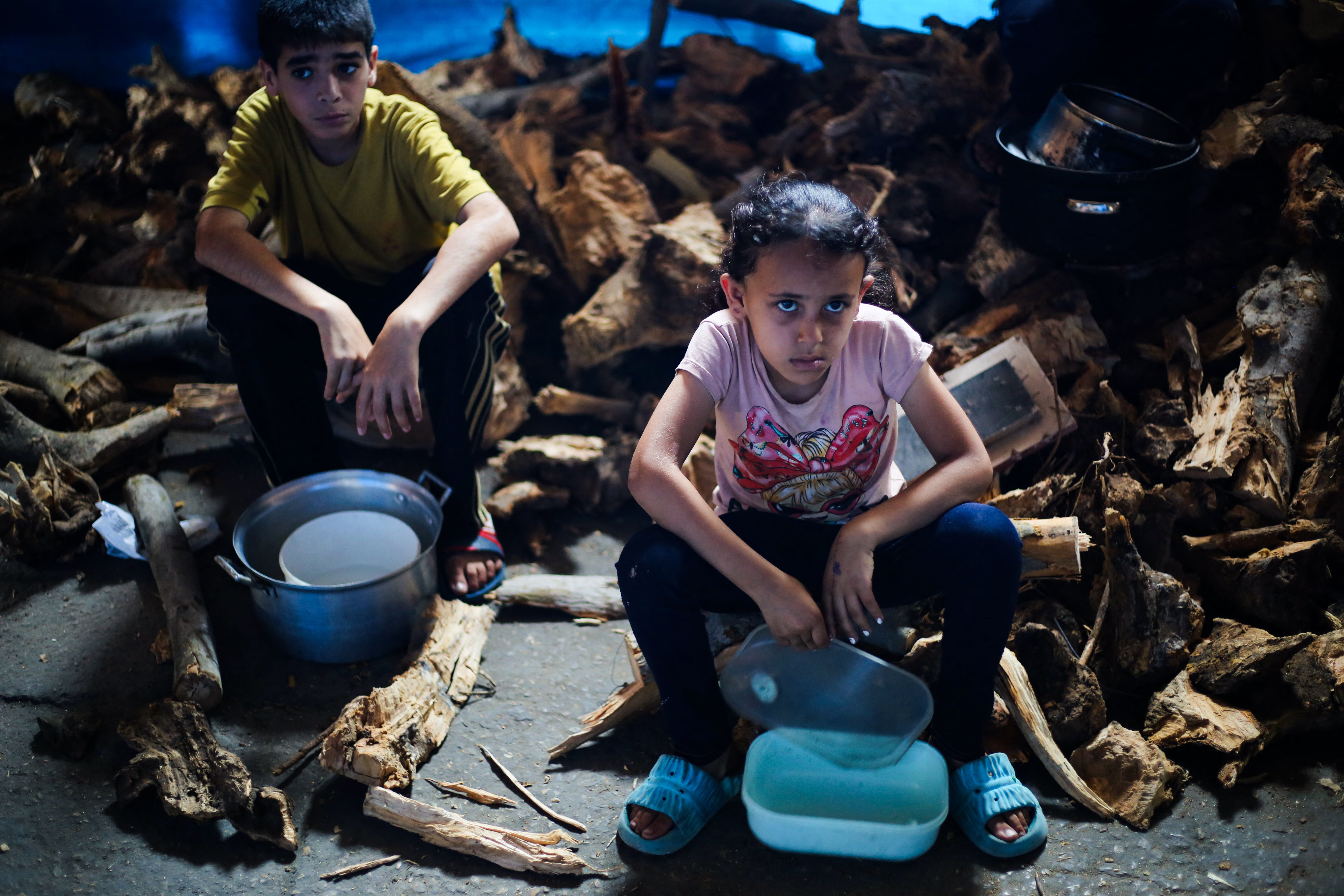 Palestinian children wait for food at a distribution point in Nuseirat, Gaza, on Monday