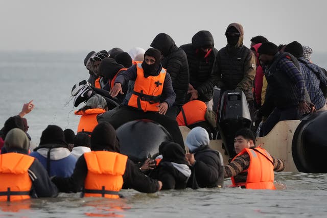 <p>People wade through the sea to board a small boat leaving the beach at Gravelines, France, earlier this month</p>