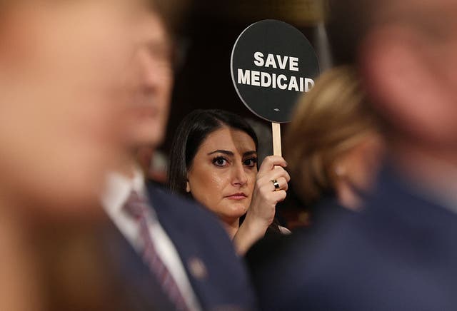 <p>Congresswoman Sarah Jacobs holds a sign reading 'save Medicaid' during Donald Trump's address to a joint session of Congress</p>