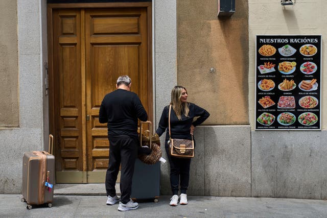 <p>Tourists wait at the entrance of a building in downtown Madrid, Spain, Tuesday, June 3, 2025. (AP Photo/Bernat Armangue)</p>