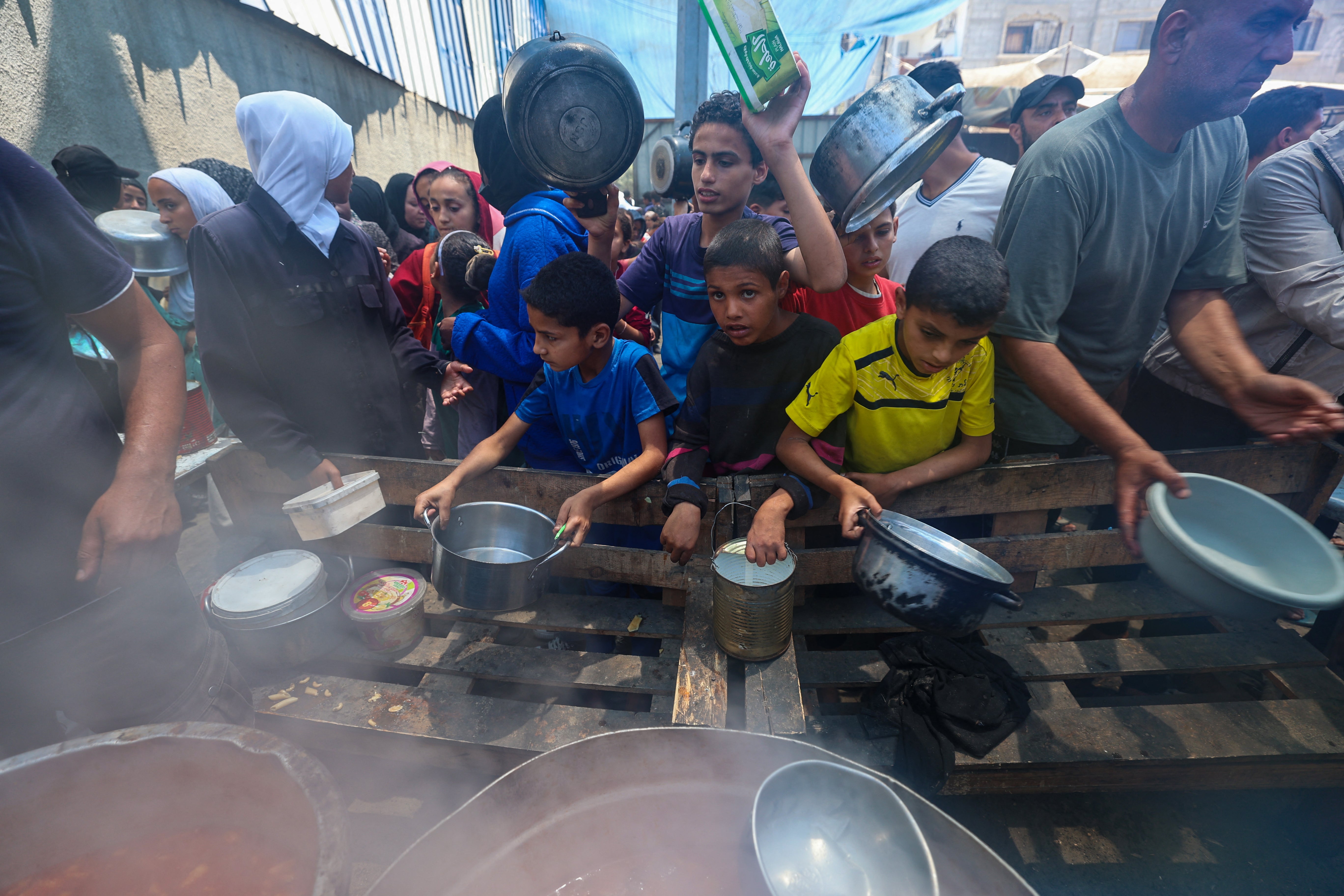 Palestinians waited for meals at a distribution point in Nucrat, Central Gaza Strip, 2 June 2025