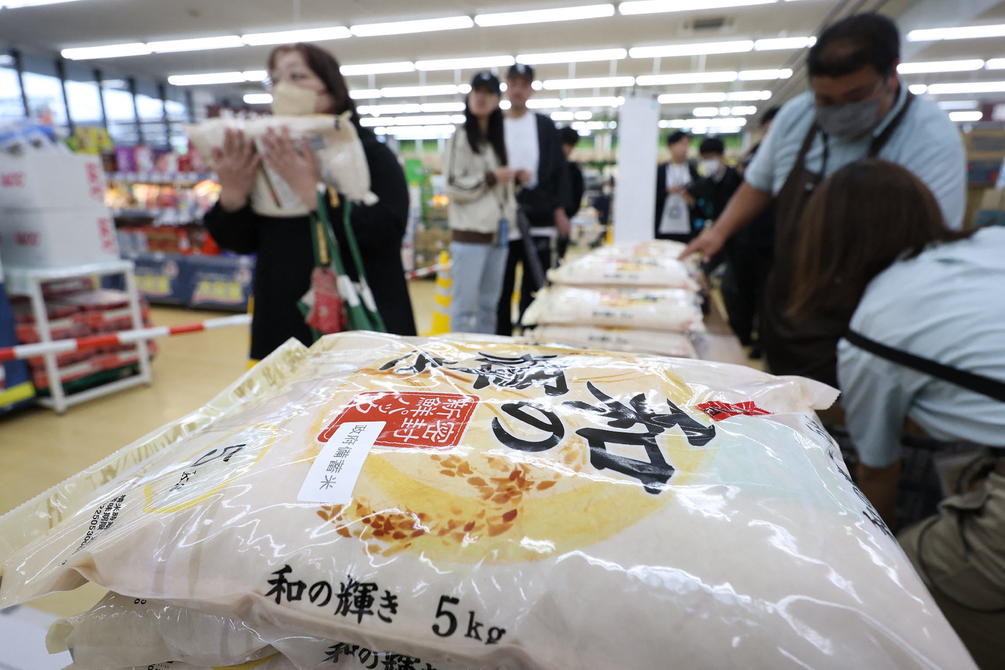 <p>Customers buy stockpiled rice which went on sale at a store in the city of Sendai, Miyagi prefecture</p>