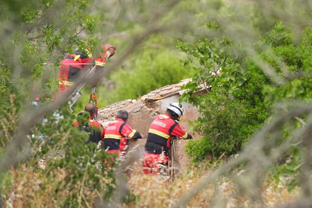 <p>Firefighters and search teams check a well near Praia da Luz</p>