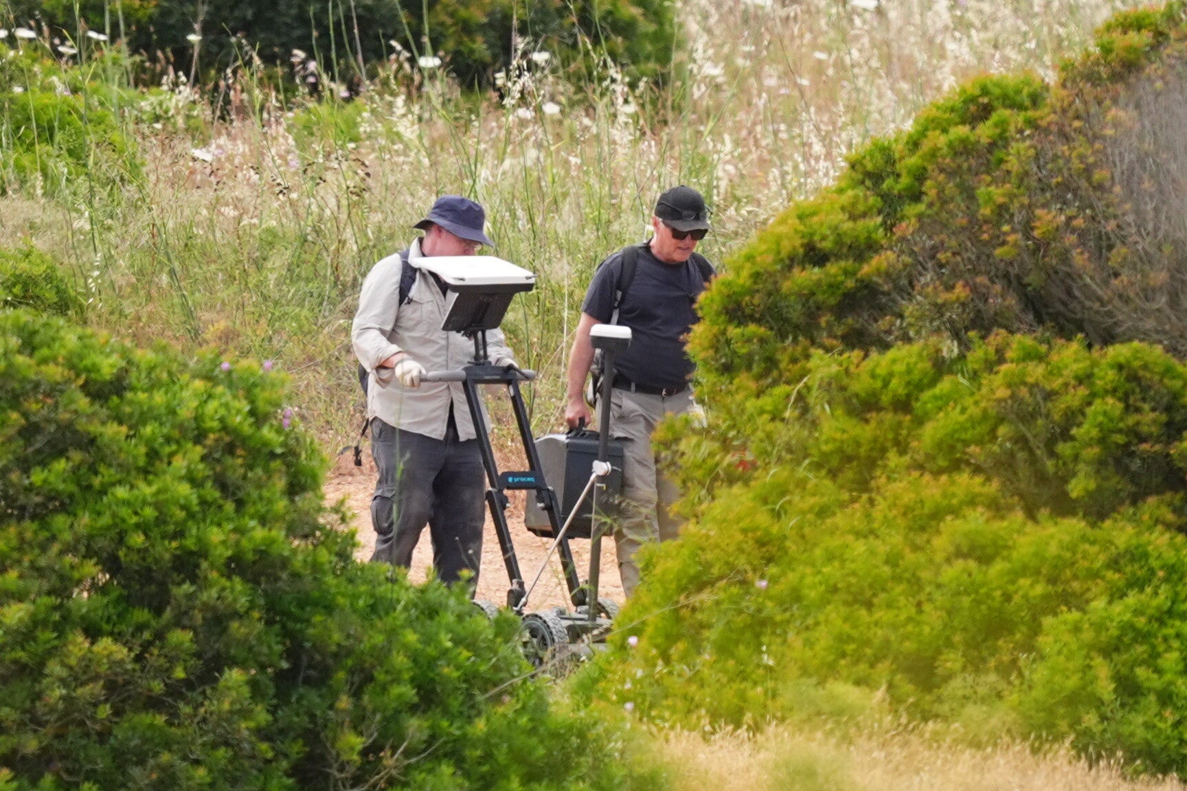 Search teams use ground penetrating radar next to a derelict and abandoned property