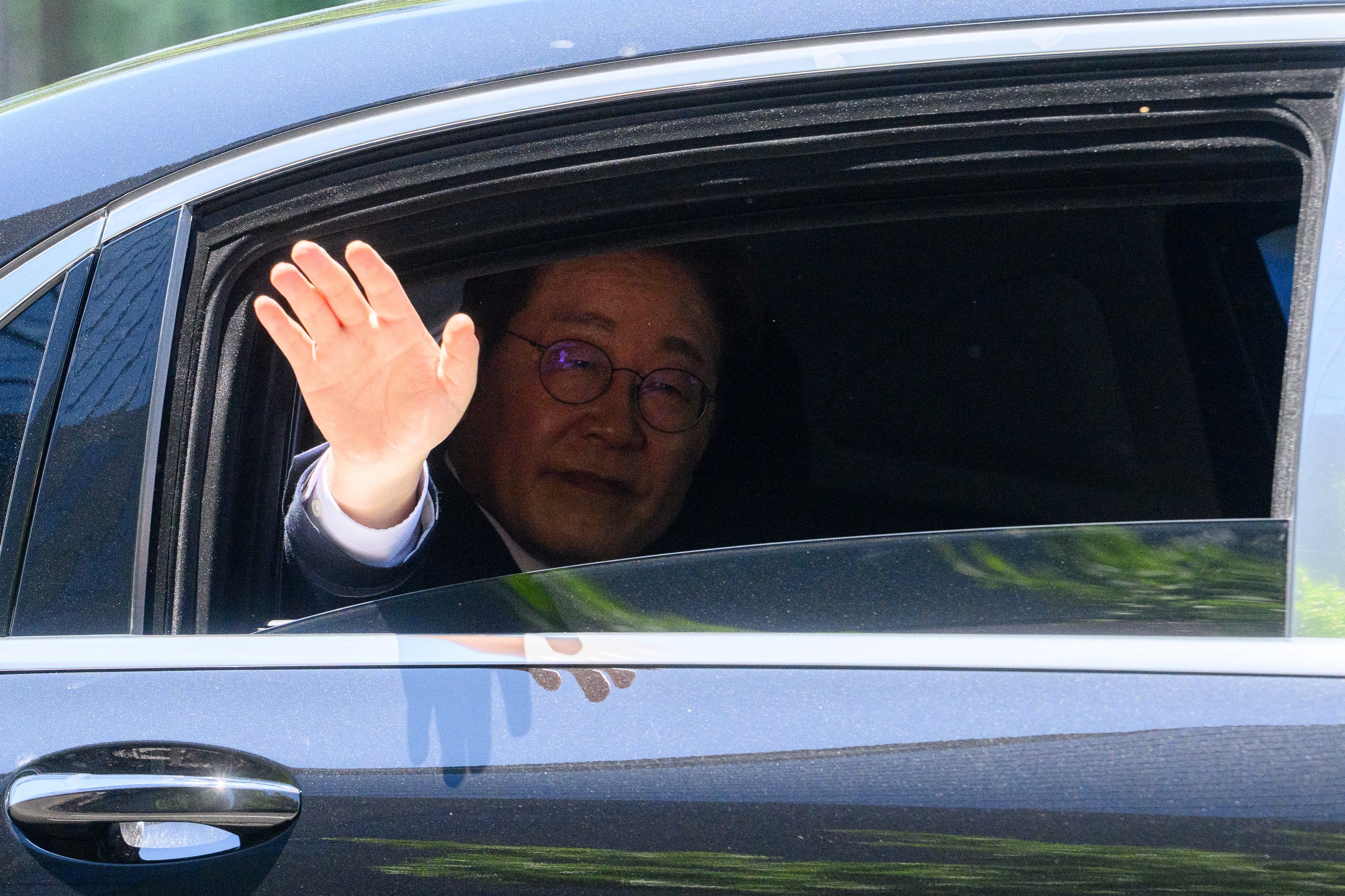 South Korea's newly elected president Lee Jae Myung waves from his car as he departs to the presidential office from the National Assembly following his inauguration in Seoul on 4 June 2025