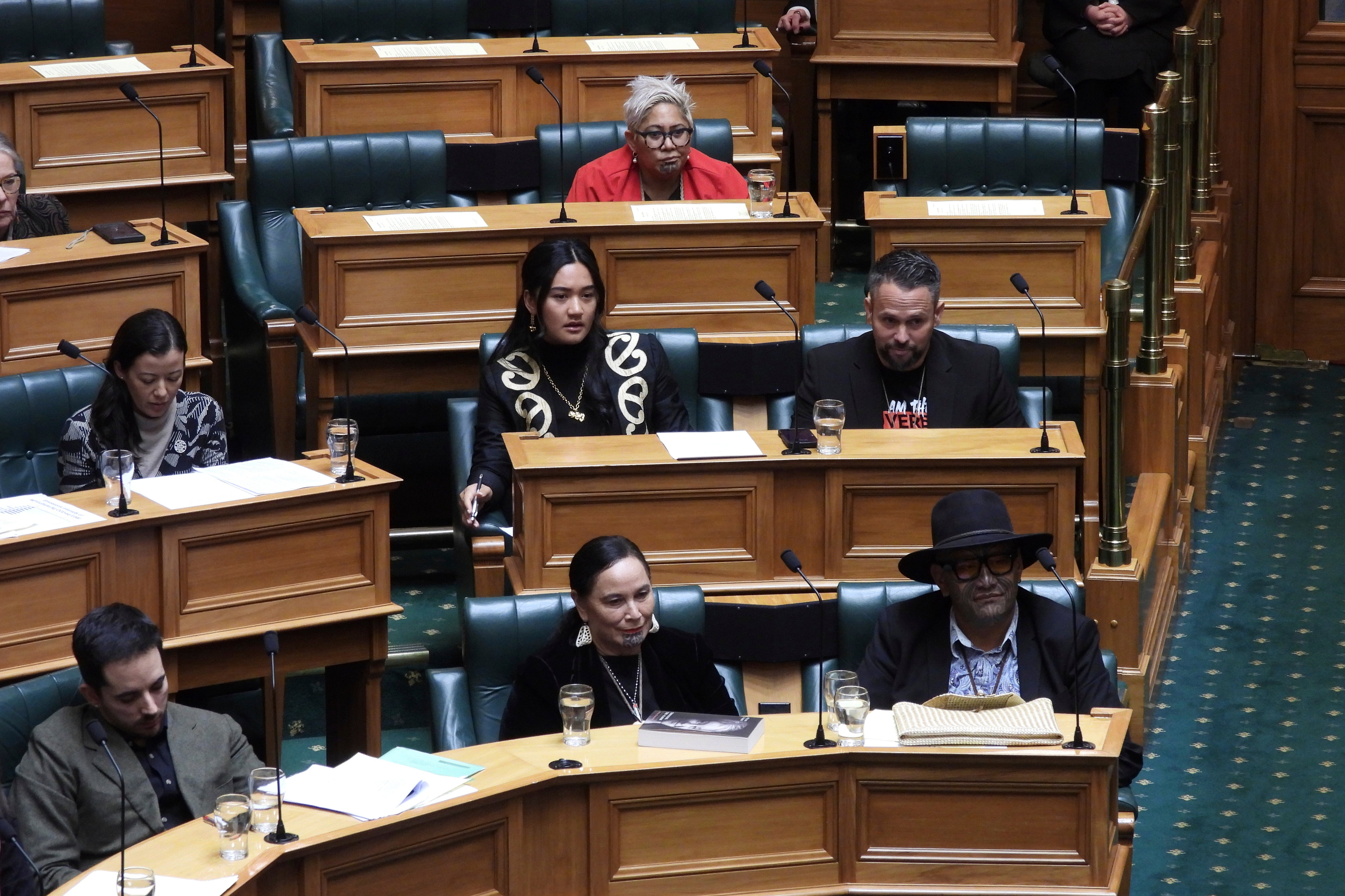 New Zealand lawmakers, Hana-Rāwhiti Maipi-Clarke, center at second row, Debbie Ngarewa-Packer, center in front row, and Rawiri Waititi, bottom right, who received lengthy suspensions from Parliament for a protest haka they performed last November