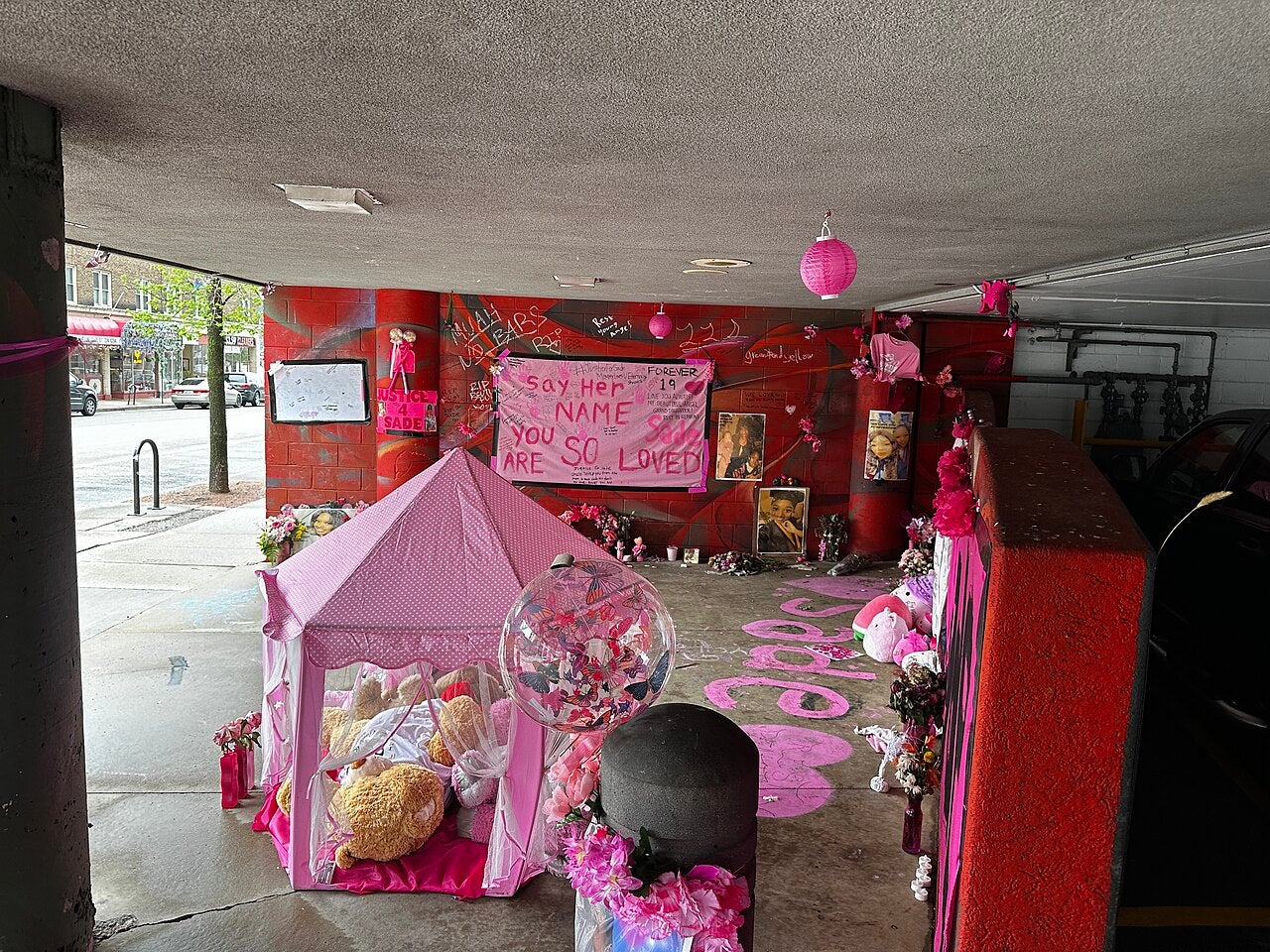 A pink makeshift memorial to Sade Robinson in the parking lot of the Pizza Shuttle where she worked