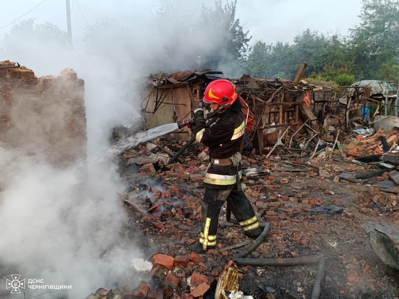 A firefighter works at a site of buildings hit by a Russian drone strike in the town of Pryluky, Chernihiv region, Ukraine