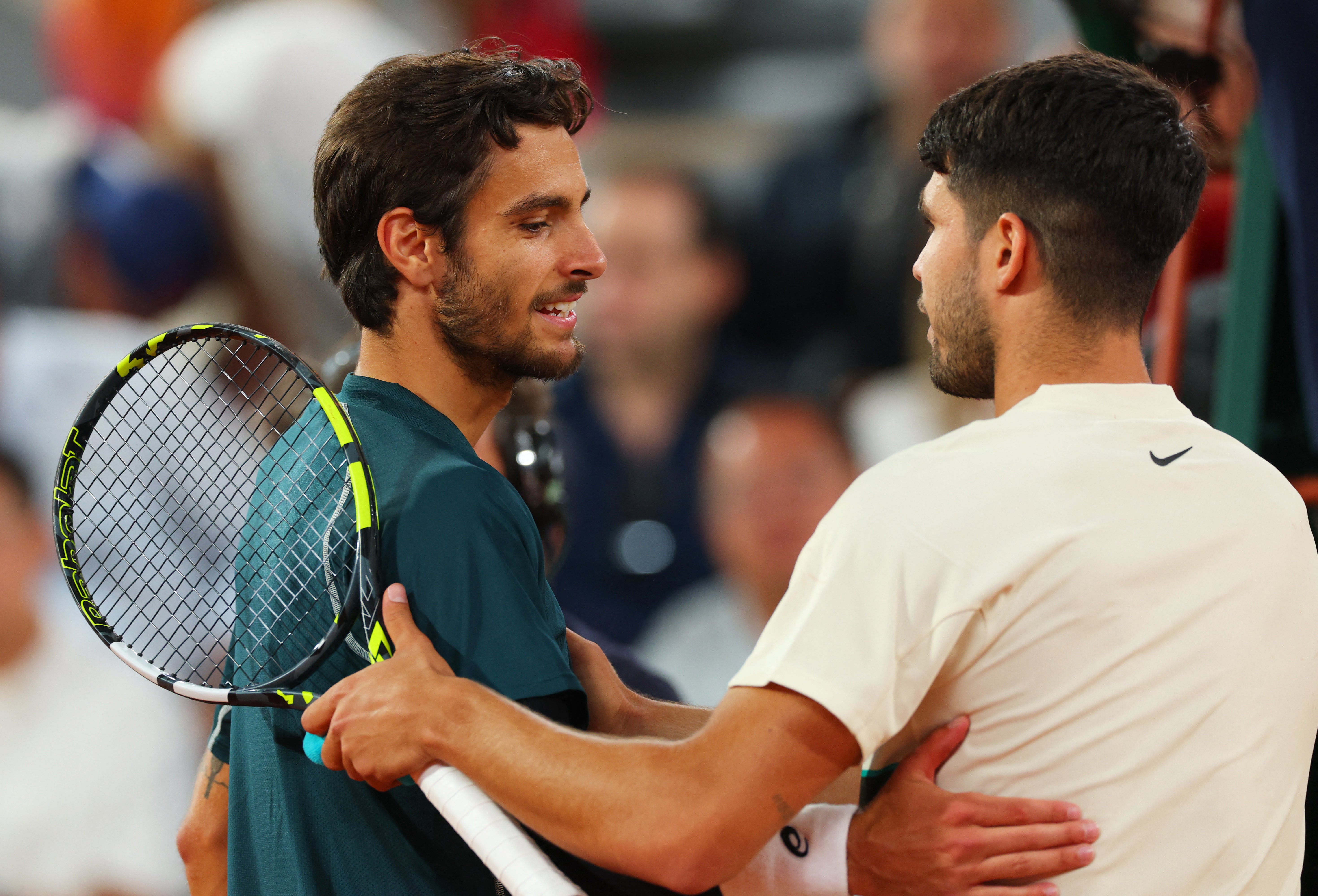 Carlos Alcaraz shakes hands with Lorenzo Musetti after the Italian’s retirement