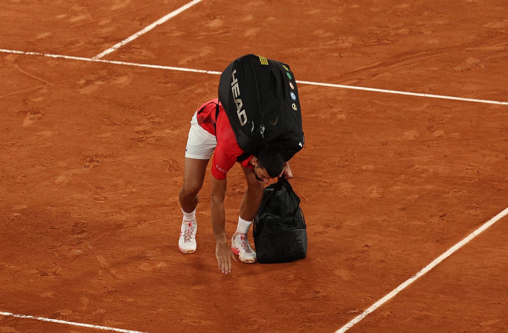 Djokovic touches the clay as he exits the French Open unsure if he will return
