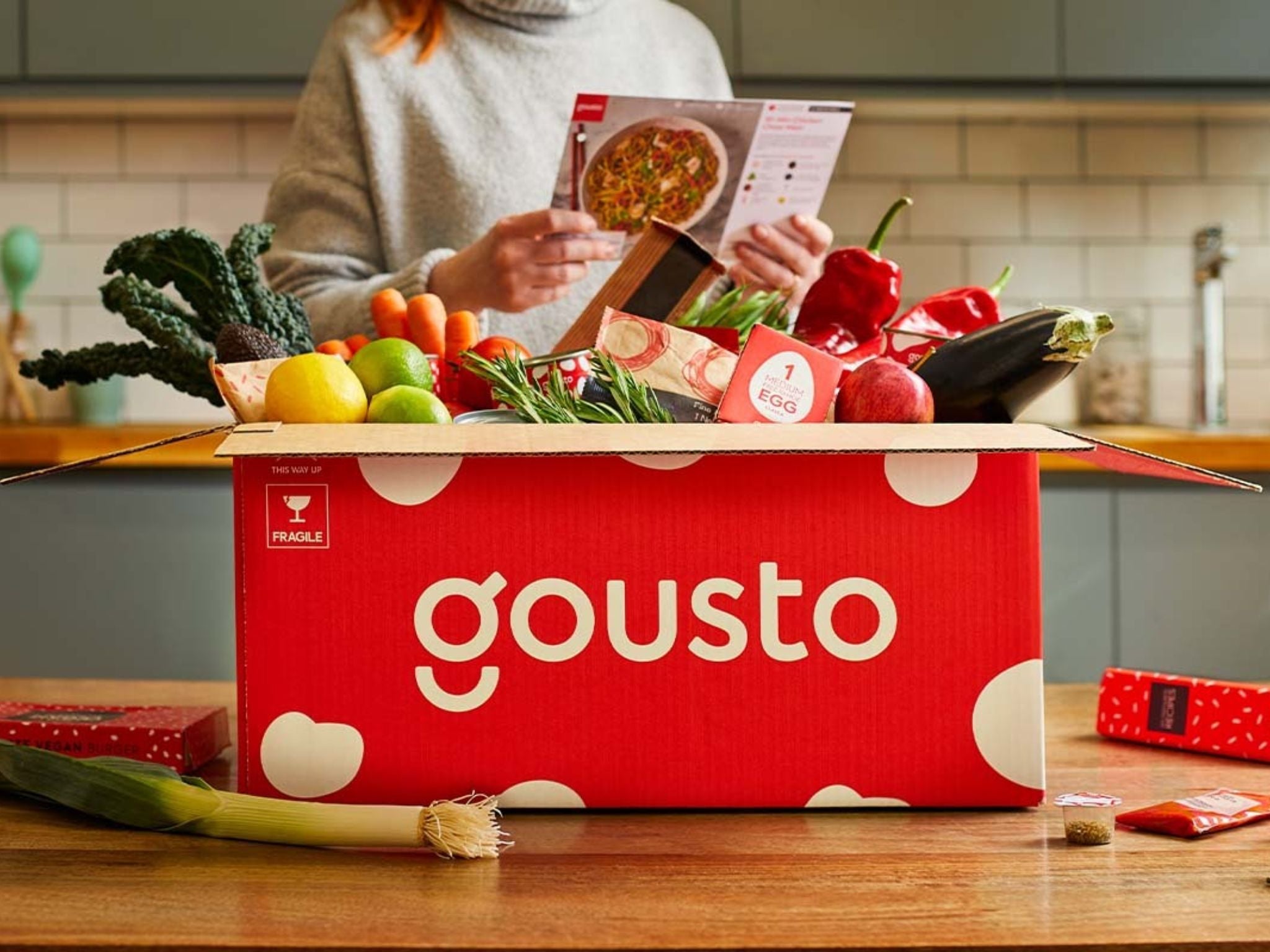 A woman cooking from a Gousto box
