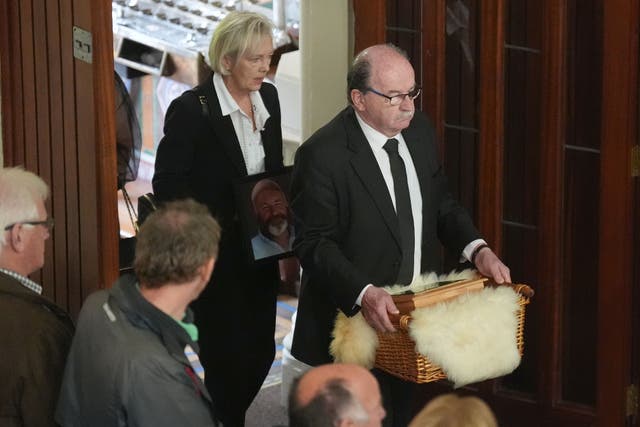 The urn of murdered Co Kerry farmer Michael Gaine is carried into the Holy Cross Church in Kenmare for his funeral (Niall Carson/PA)