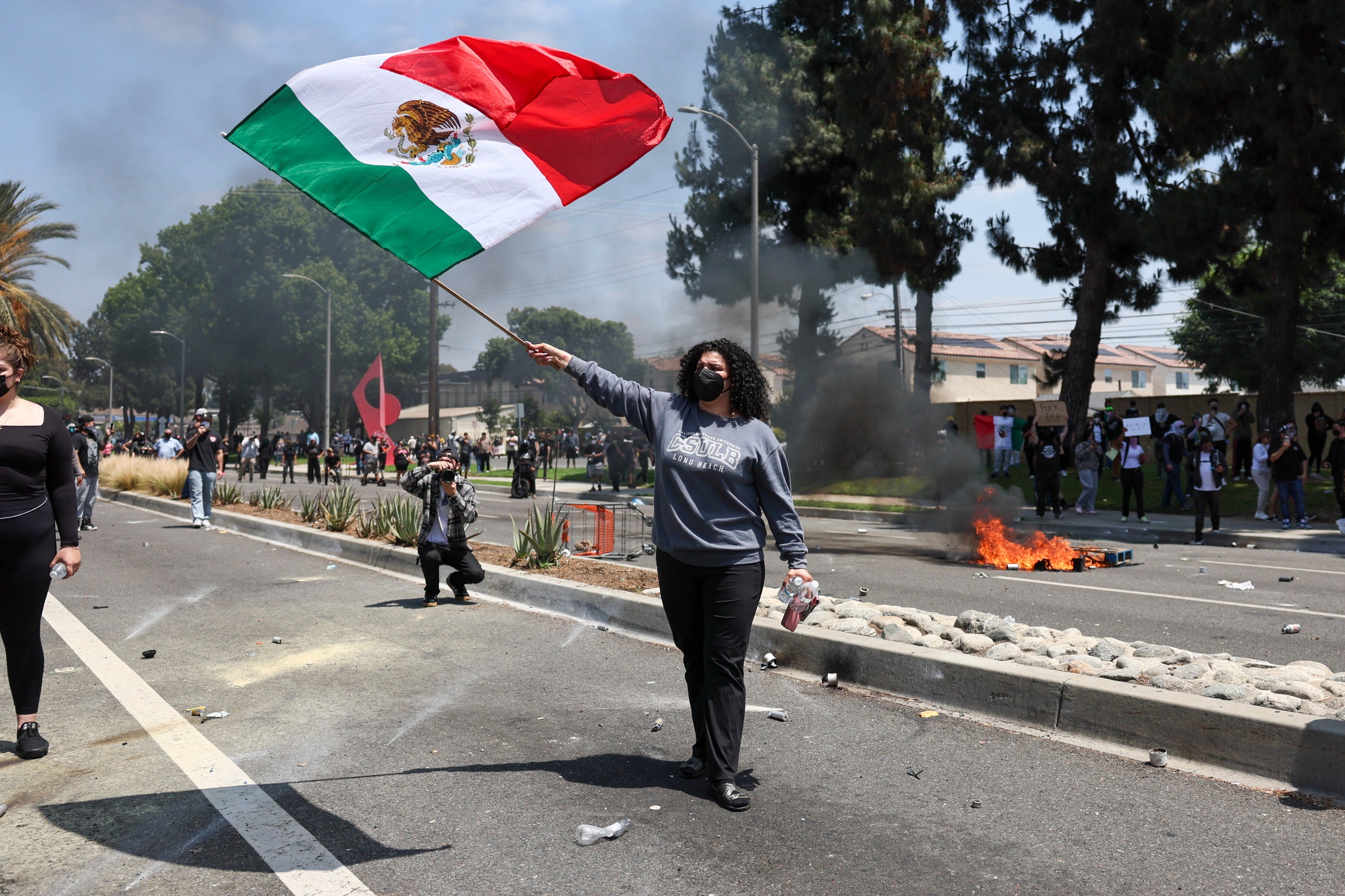 Protester waves Mexican flag in the middle of a state near the household warehouse after the raid spent judged dry