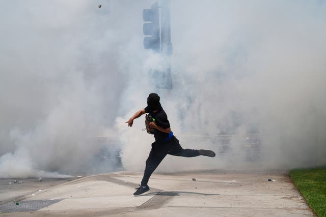 <p>A protester throws a rock amidst tear gas from law enforcement during a demonstration after federal immigration authorities conducted operations, Saturday, June 7, 2025, in the Paramount section of Los Angeles</p>