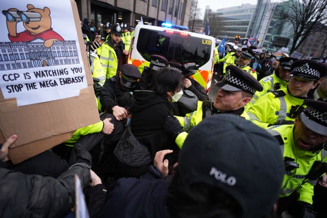 Police officers hold back protesters outside the proposed site of the new Chinese embassy redevelopment in Royal Mint Court in central London (PA)