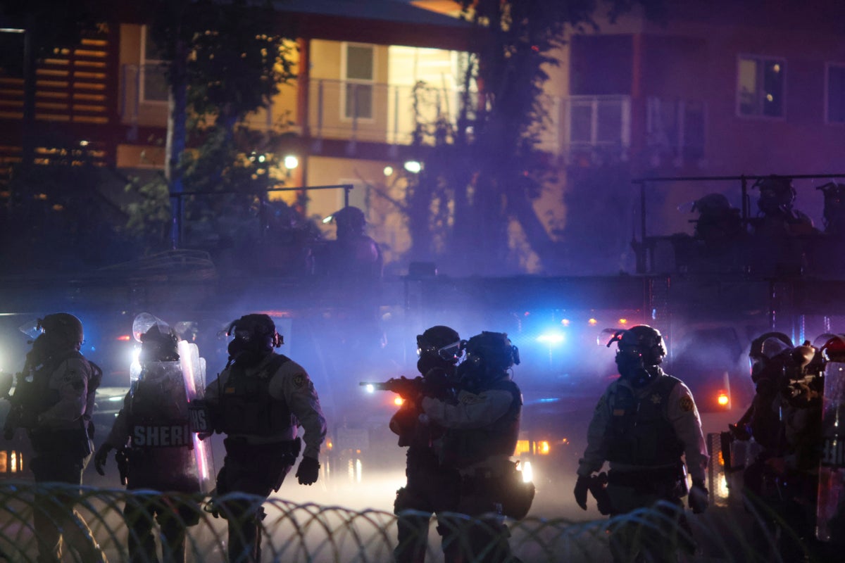 After tear gas and street fires, an Los Angeles community cleans up as National Guard troops arrive
