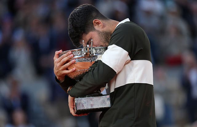 <p>Carlos Alcaraz hugs the French Open trophy</p>
