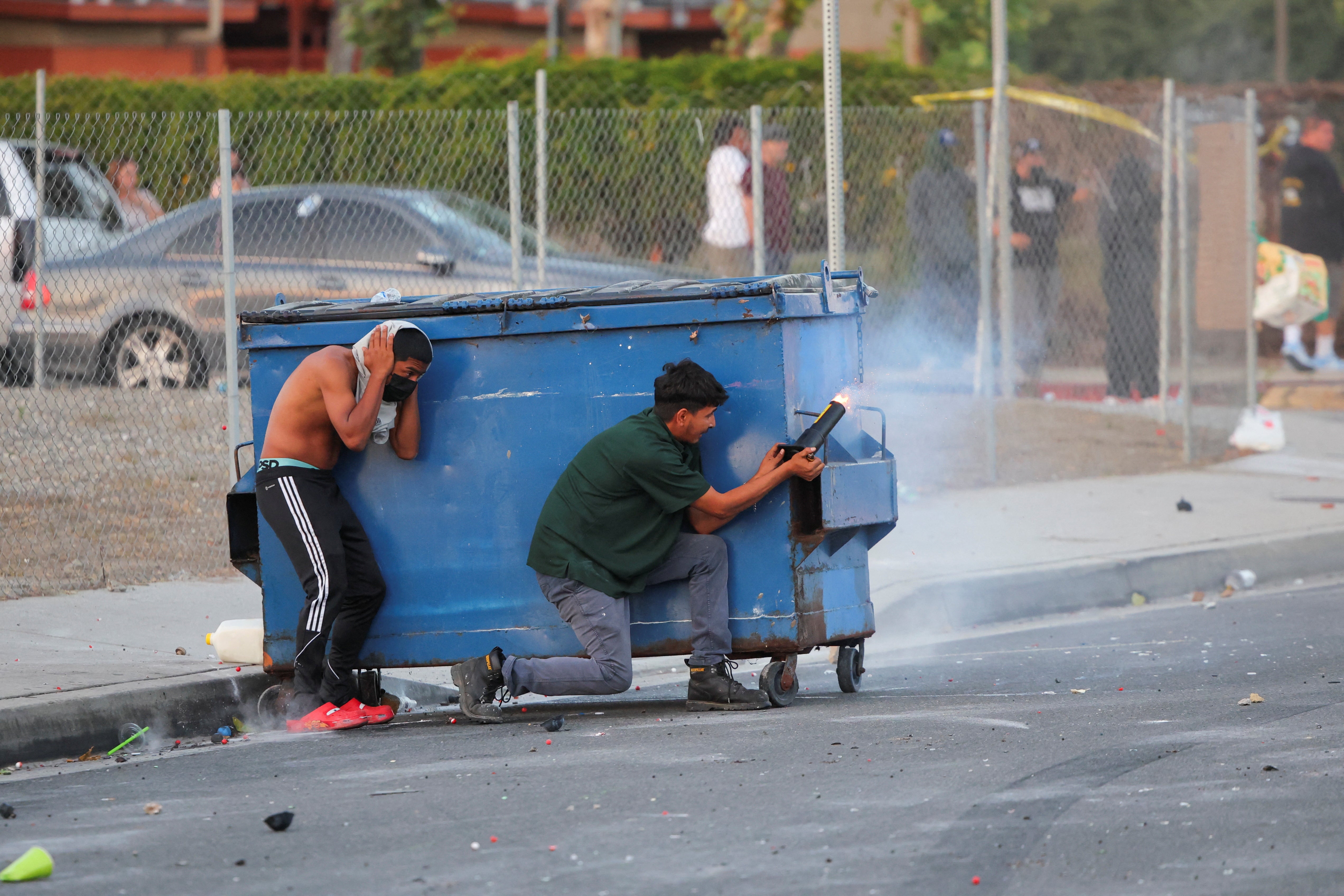 A protester shoots a firework towards law enforcement officers