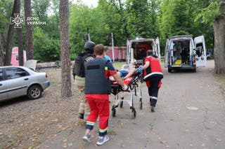 Paramedics carry a resident to an ambulance after she was wounded during a Russian air strike