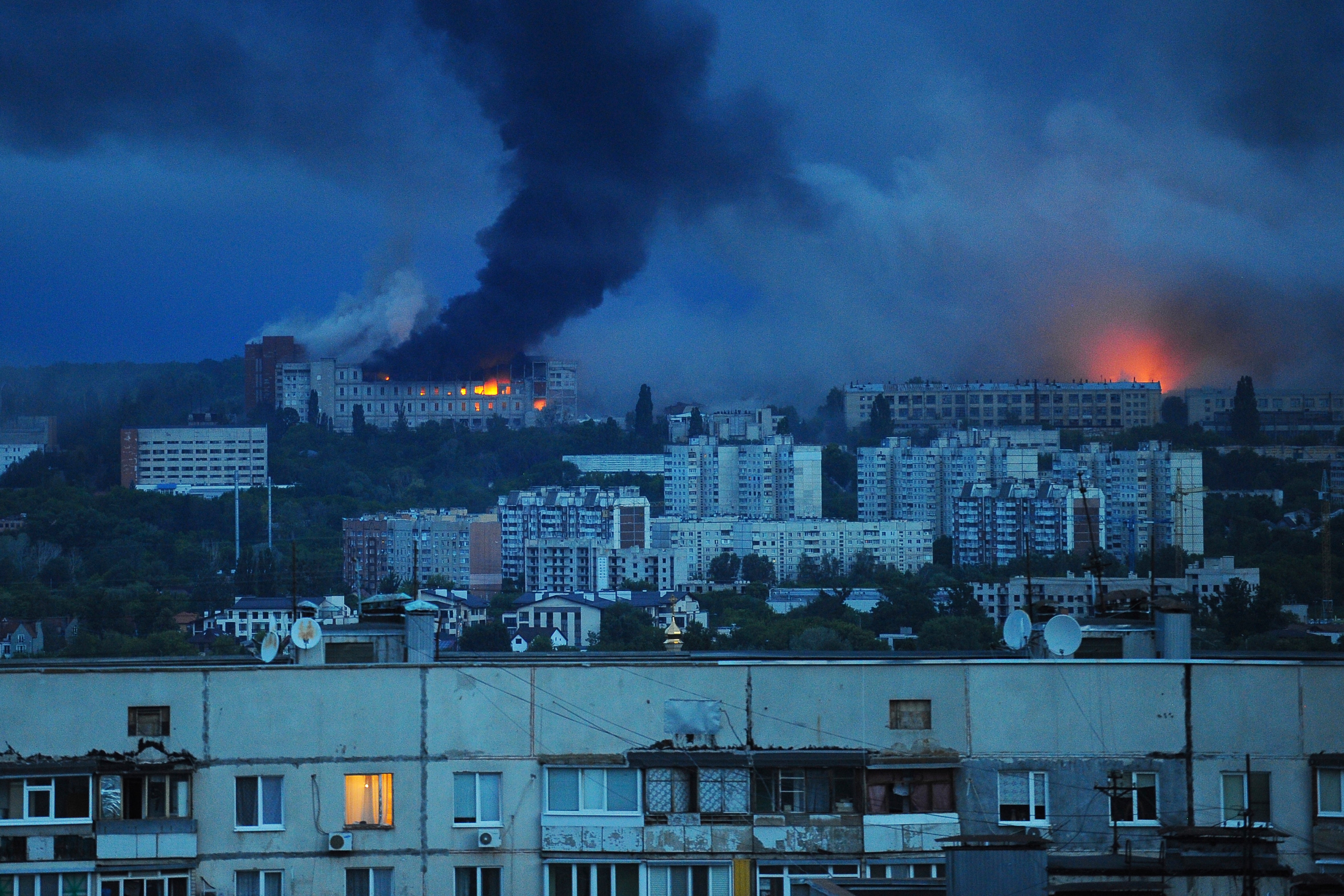 Fire and smoke rise from the site where a Russian missile struck a residential area in Kharkiv
