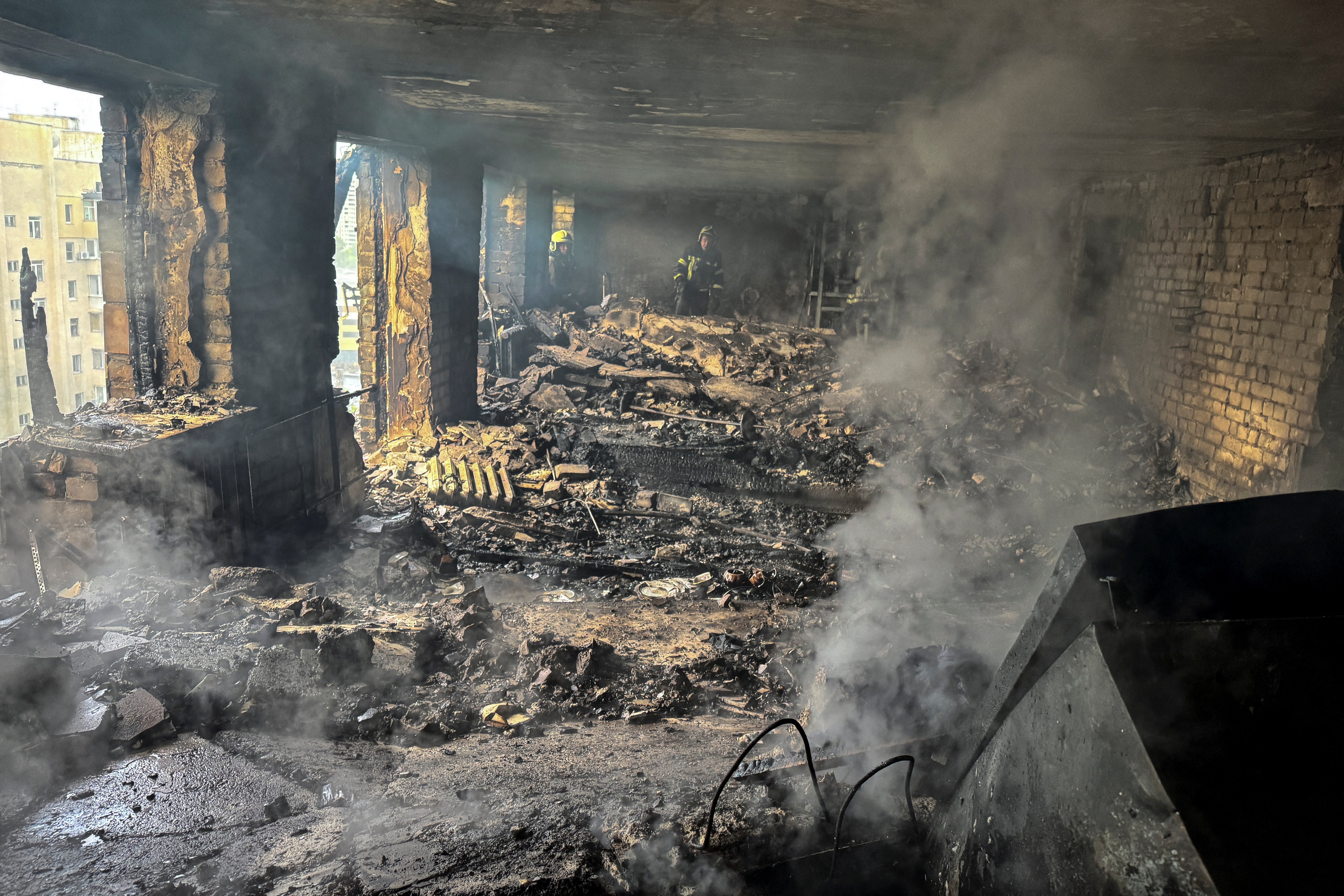 Firefighters work inside an apartment building hit by a Russian drone strike, amid Russia's attack on Ukraine, in Kharkiv