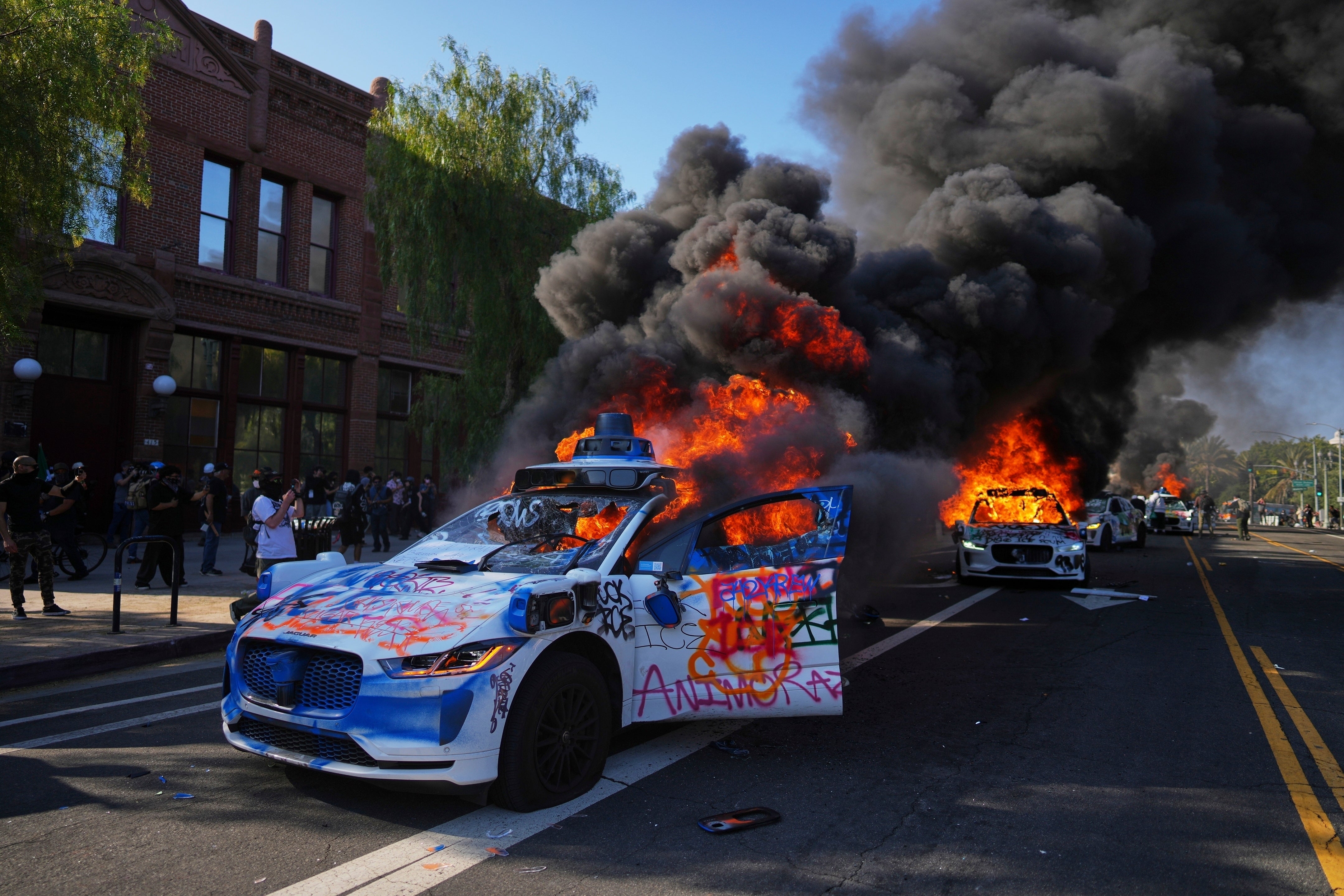 Multiple Waymo taxis burned near the Metropolitan Detention Center of downtown Los Angeles on Sunday during the riots