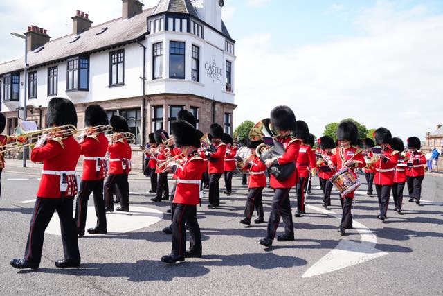 Members of the Coldstream Guards, wearing their full ceremonial dress of scarlet tunics and bearskin caps, parade through their birthplace in Berwick-upon-Tweed (PA)