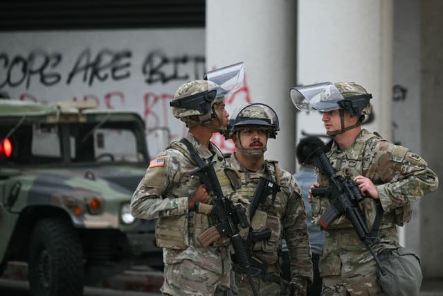 <p>Members of the California National Guard stand watch outside the Edward R. Roybal Federal Building on Tuesday morning</p>
