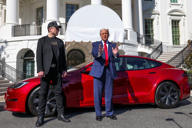 <p>Elon Musk stands next to President Donald Trump with a Tesla car in the background. Musk was once considered the 'First Buddy' as he maintained a seemingly close relationship with Trump throughout his work at the Department of Government Efficiency</p>