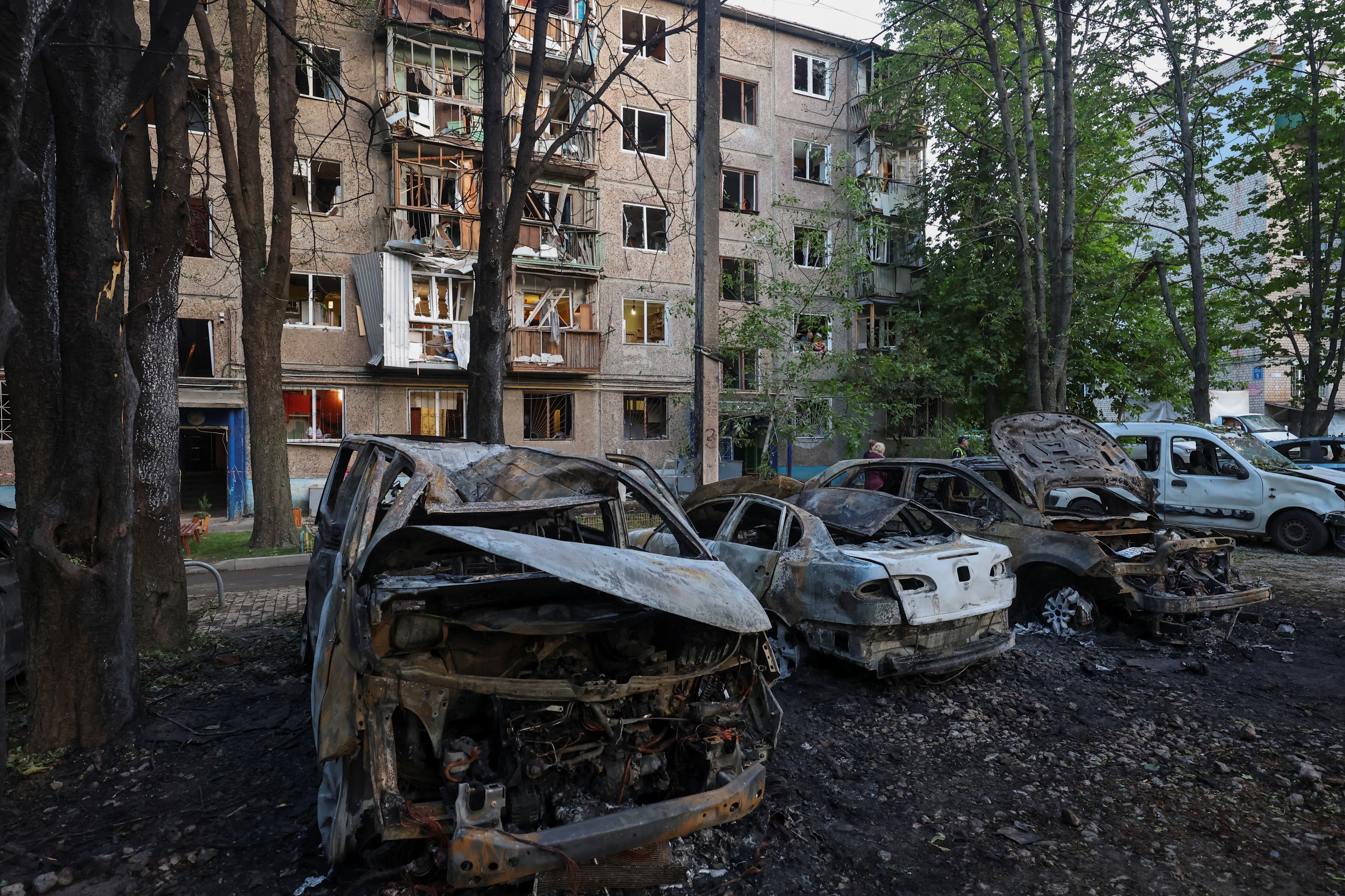 A view shows cars and apartment building damaged by a Russian drone strike, amid Russia's attack on Ukraine, in Kharkiv, Ukraine June 11, 2025
