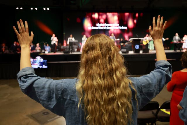 <p>A messenger attending the Southern Baptist Convention participates in worship during the 2025 SBC Annual Meeting</p>
