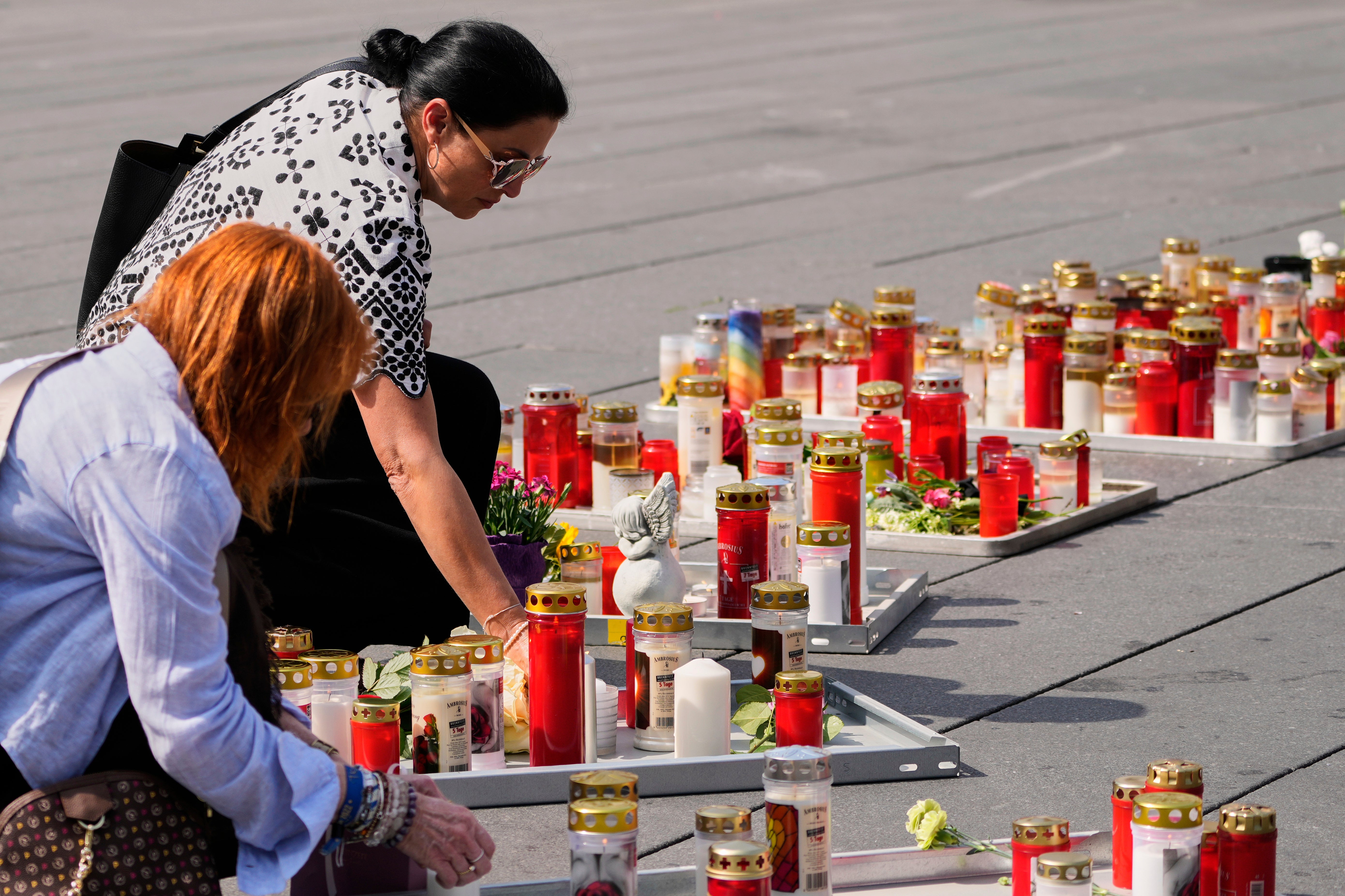 <p>People light candles on the main square in Graz, Austria (Darko Bandic/AP)</p>