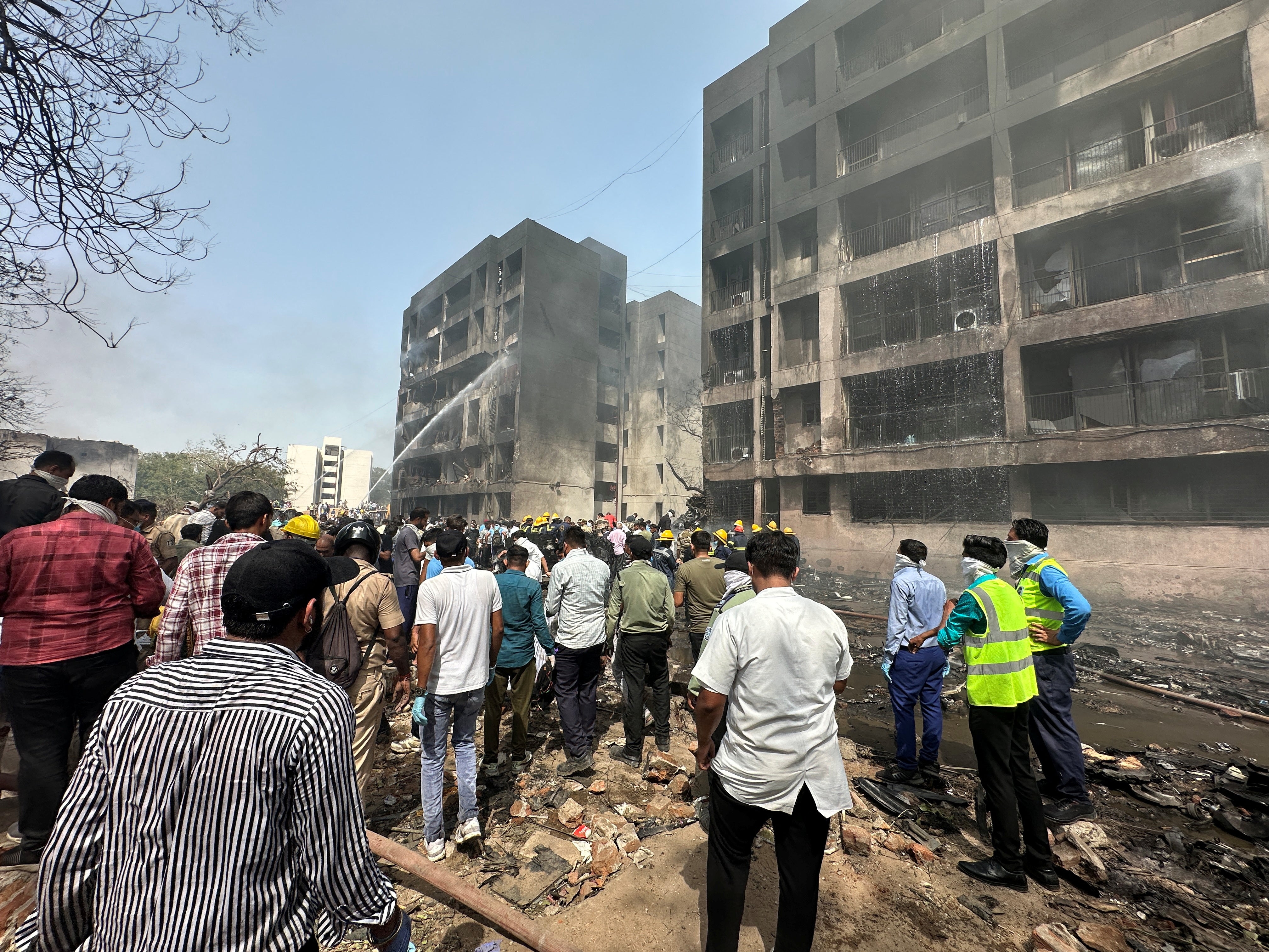 People gather by buildings damaged in crash