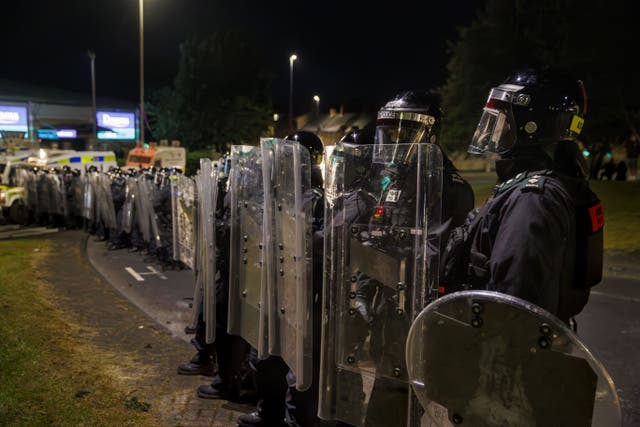 Officers from the PSNI form a barricade with riot shields during a third night of disorder in Ballymena (Liam McBurney/PA)